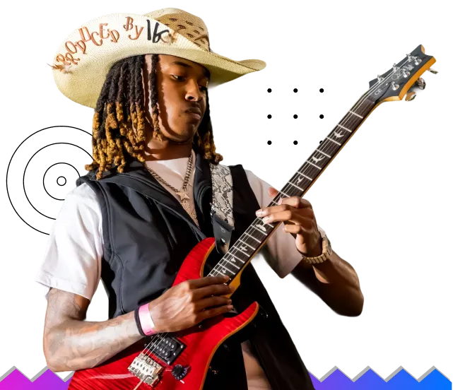 Young man with dreadlocks wearing a cowboy hat and black vest playing a red electric guitar.