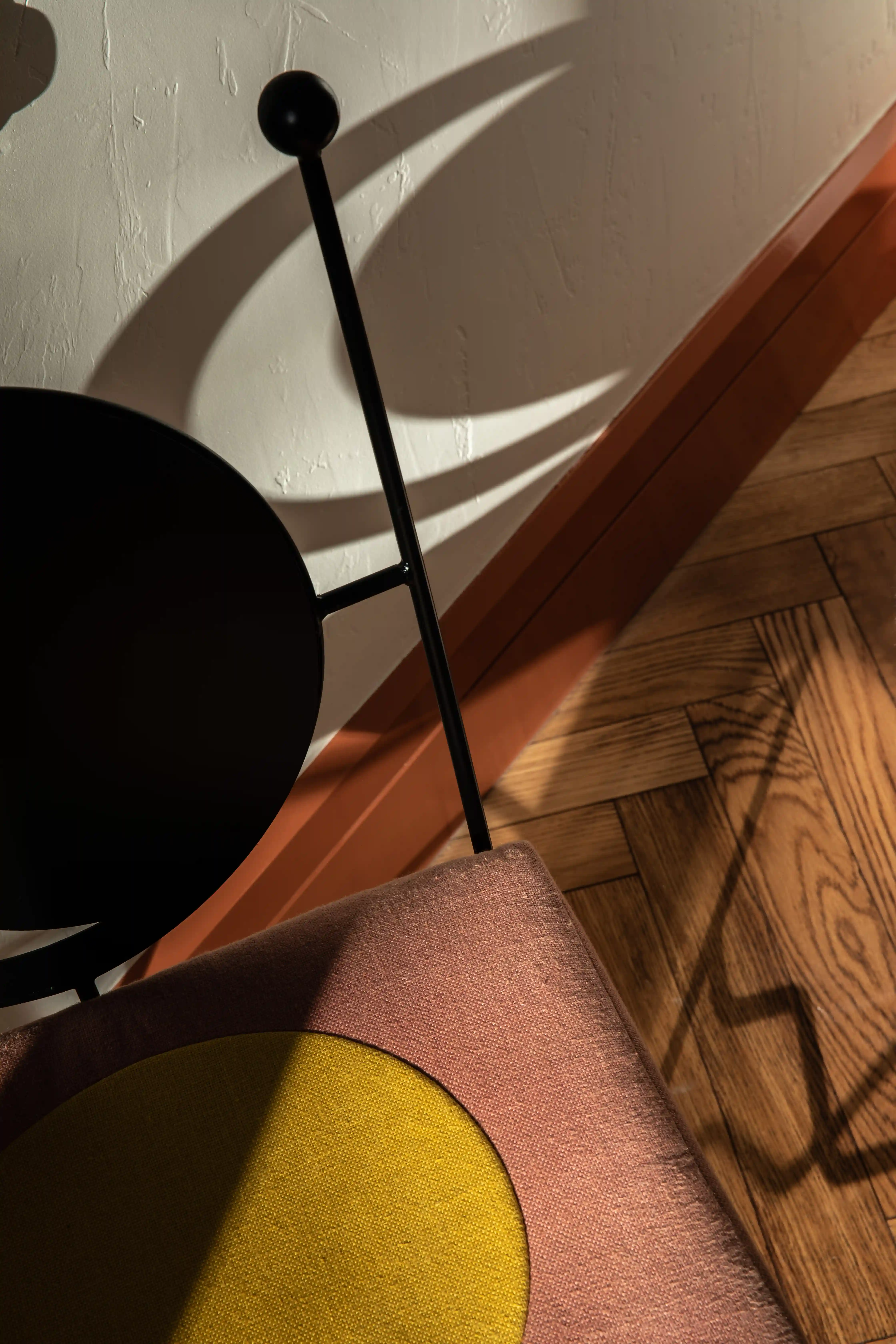 Close-up of a designer chair with a two-tone cushion and shadow play at Experimental Marais restaurant.