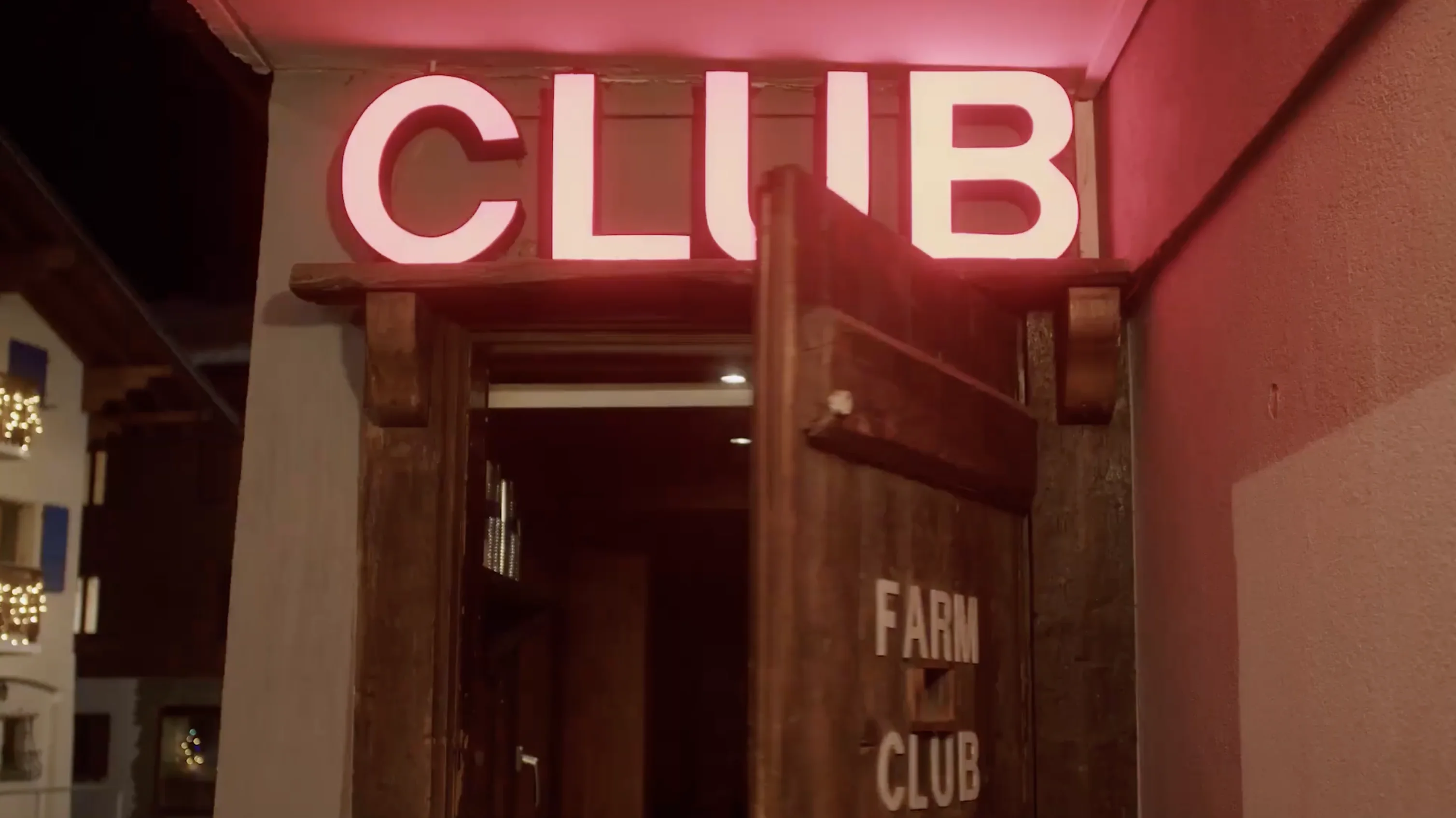 Entrance to a club with a wooden door partially open and a bright red neon sign reading 'CLUB' above it.