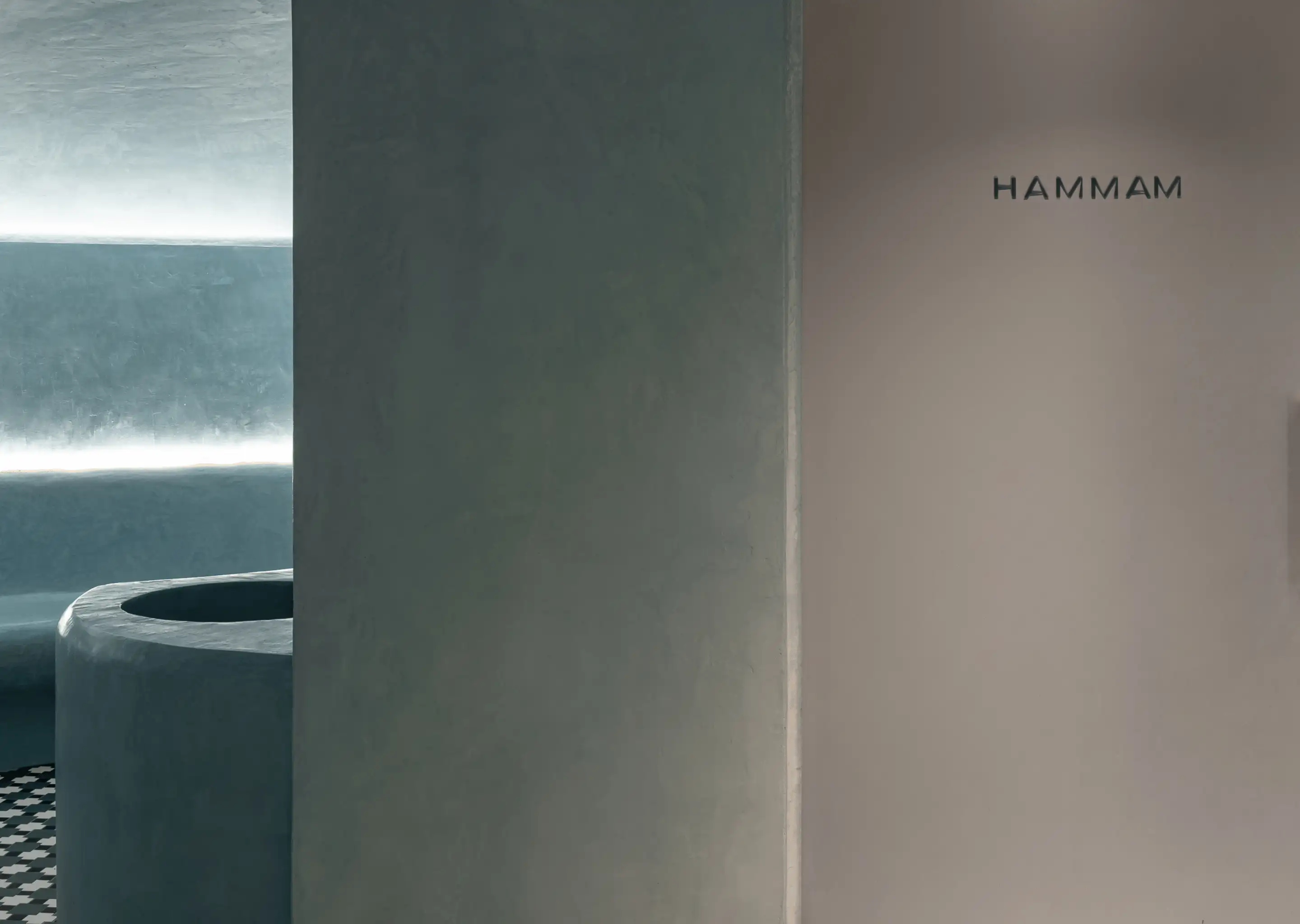 Interior of a modern hammam spa with curved seating and soft ambient lighting.