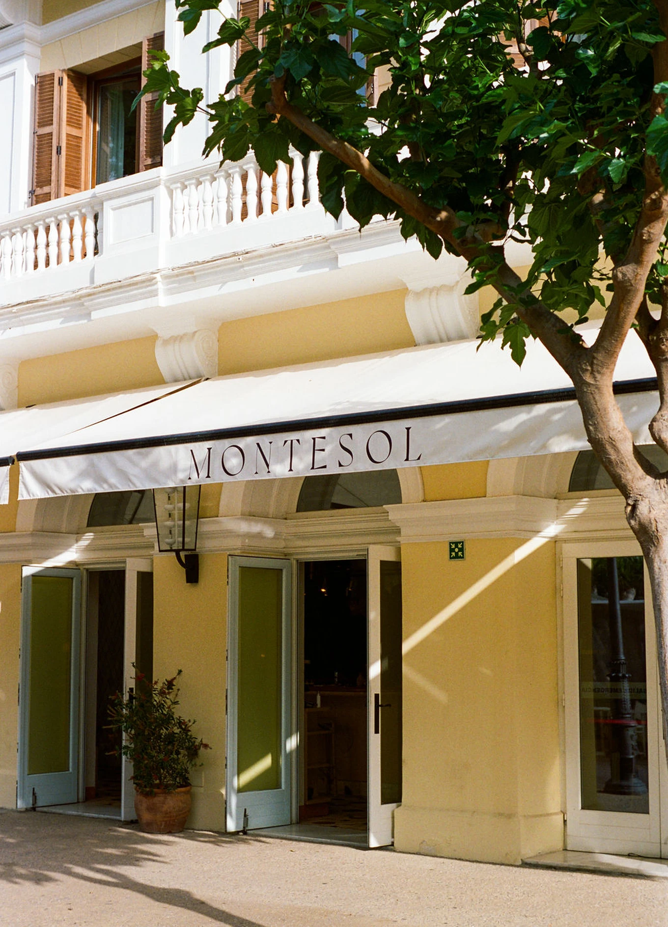 Iconica facciata gialla dell'hotel Montesol Experimental di Ibiza alla luce del giorno.