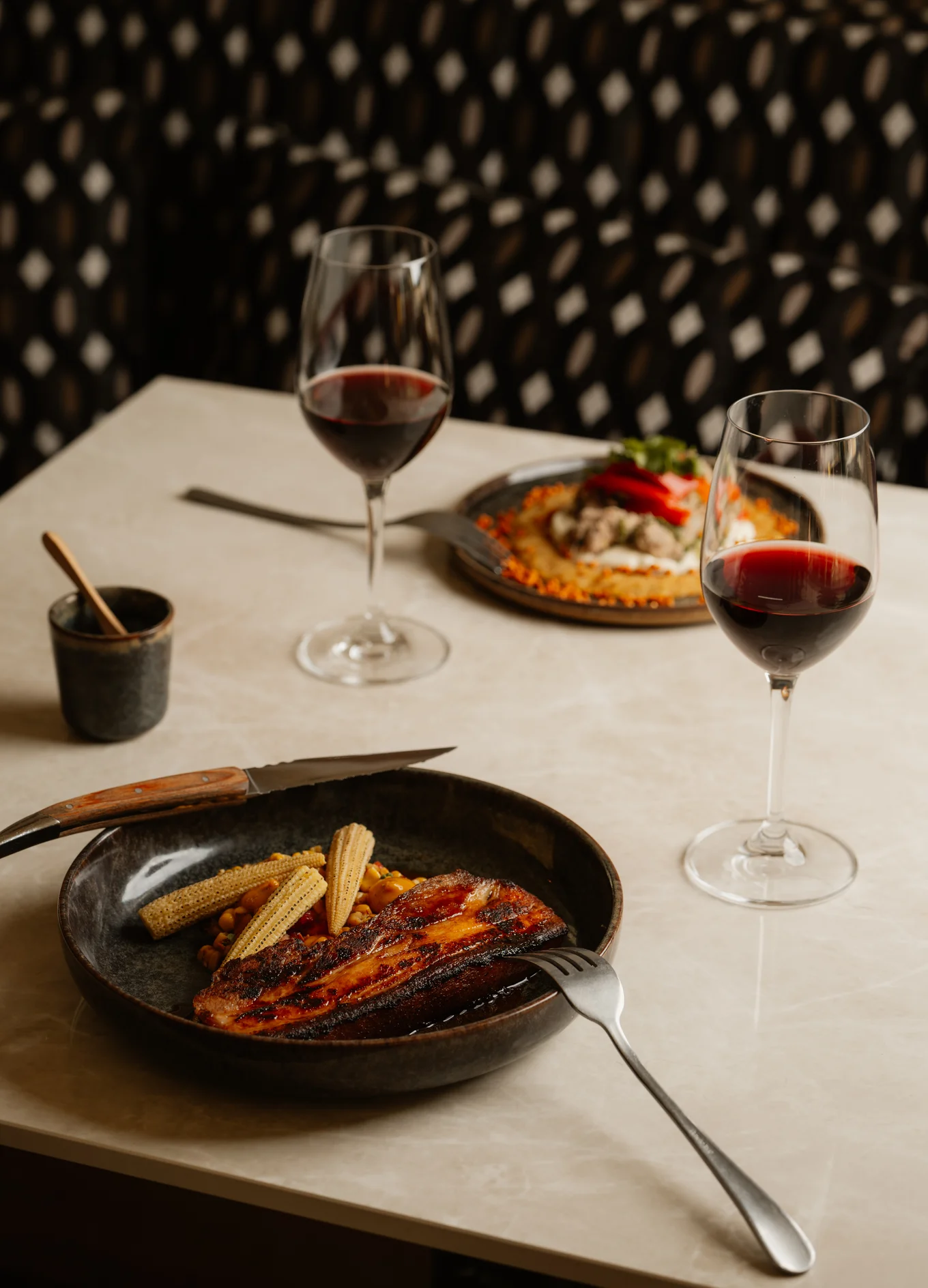 Fine dining experience with red wine at the Le Garage hotel restaurant, by Experimental Group.