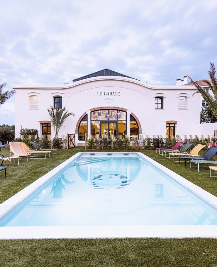 Arquitectura y exterior únicos del hotel Le Garage en Biarritz bajo un cielo crepuscular.
