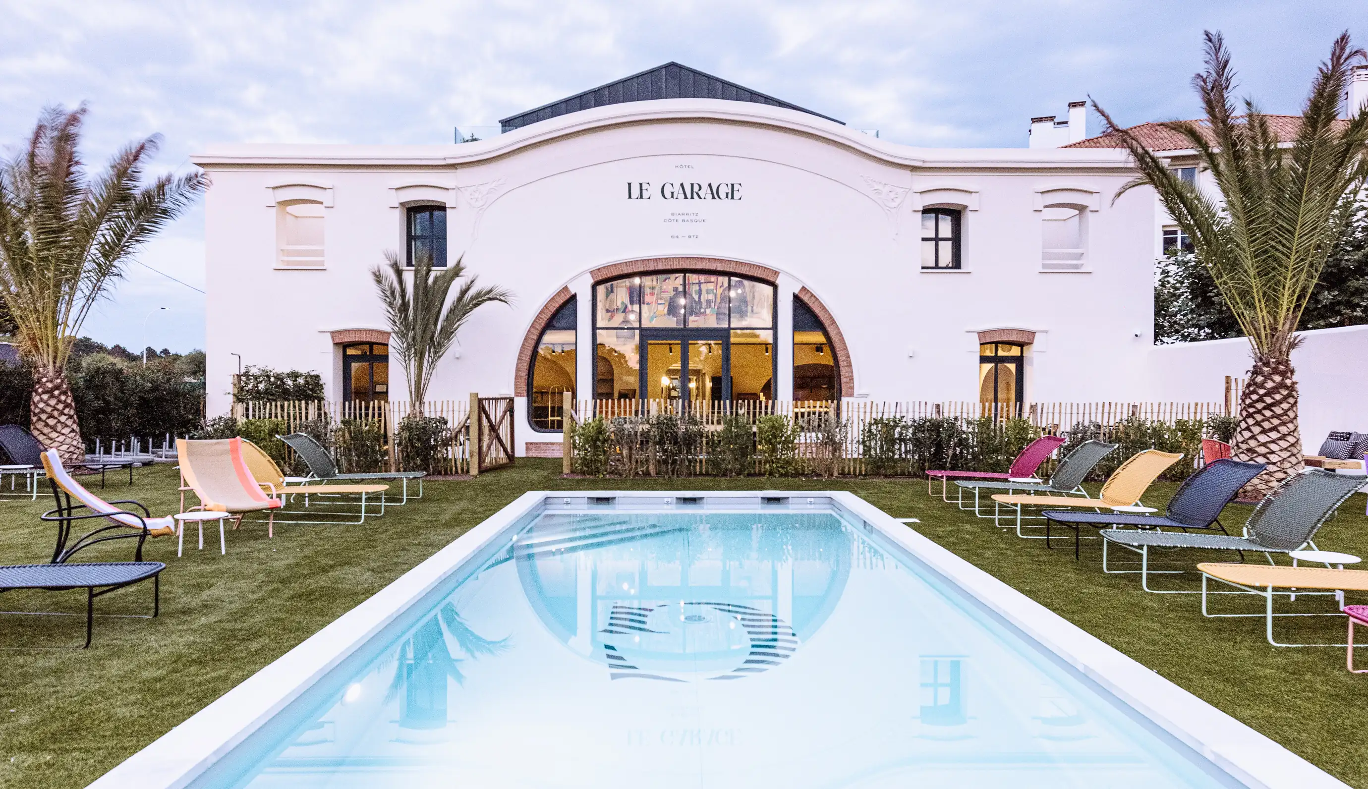 Fachada del hotel Le Garage de Biarritz con su piscina exterior y su cuidado jardín.