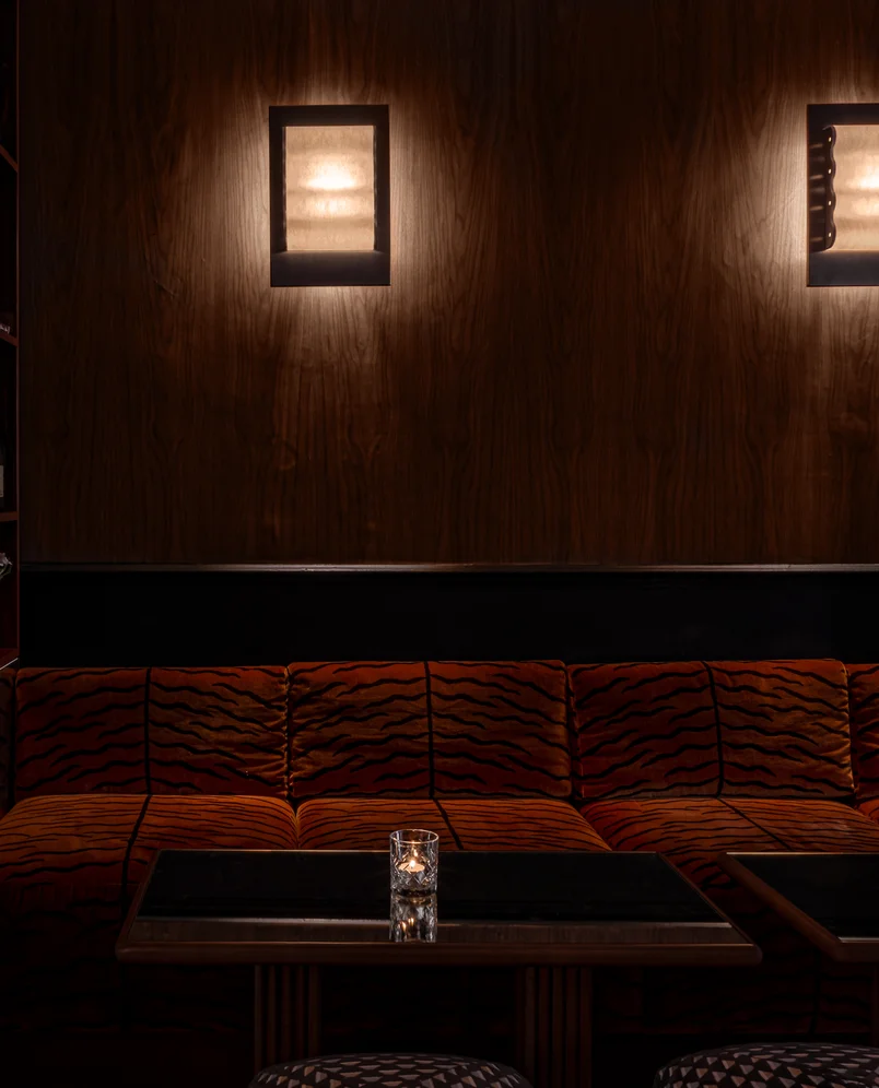 Cozy lounge seating with tiger-print velvet sofas and warm ambient lighting at Hôtel Le Garage, Biarritz.