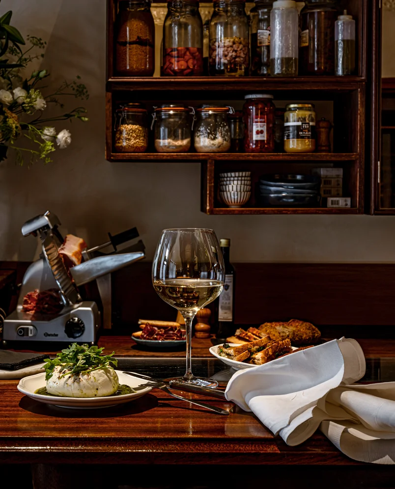 The counter at La Compagnie bar by Experimental Group with a selection of fresh products and a glass of wine.