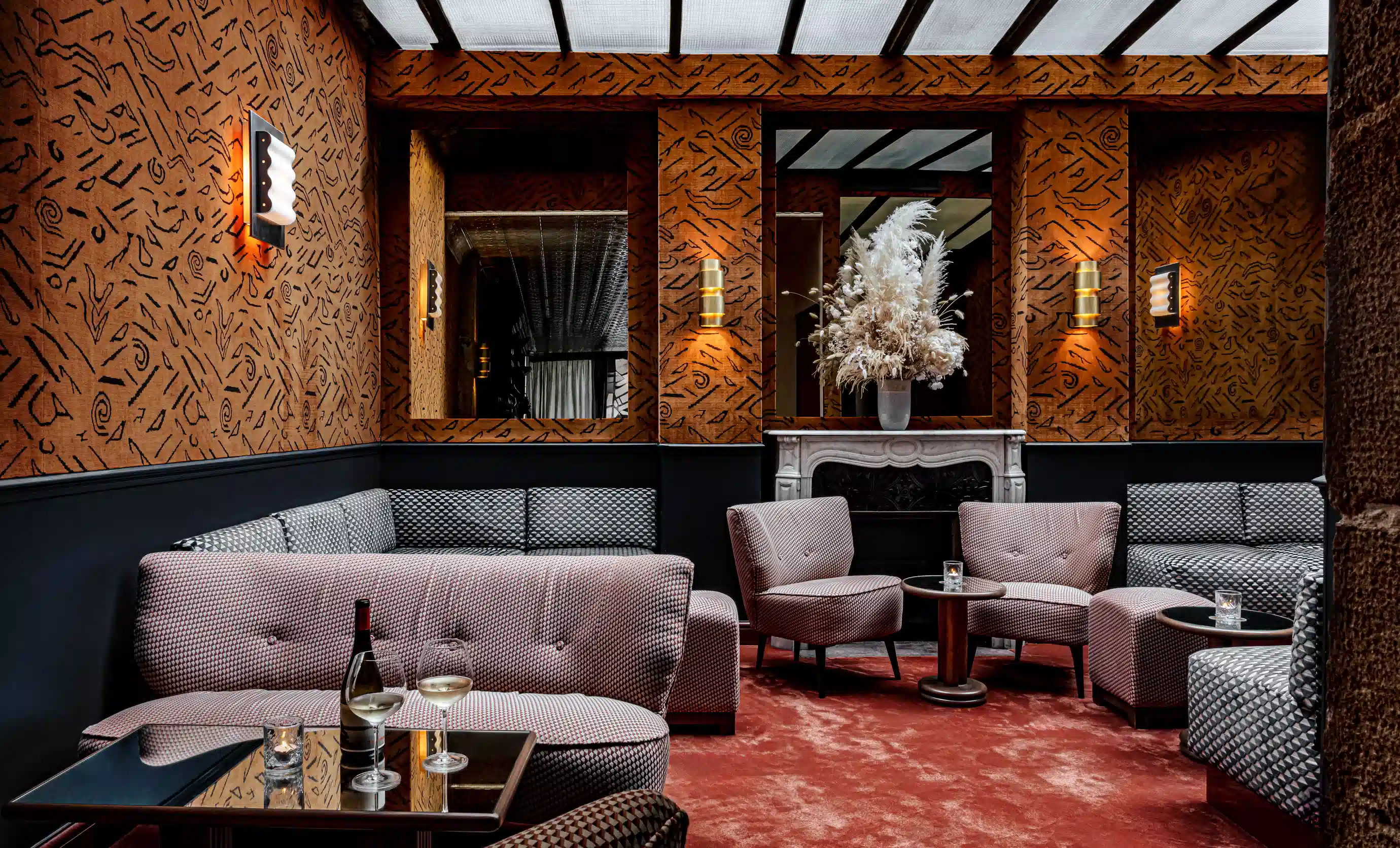 Comfortable lounge area with a fireplace and refined decor at La Compagnie bar, Experimental Group.
