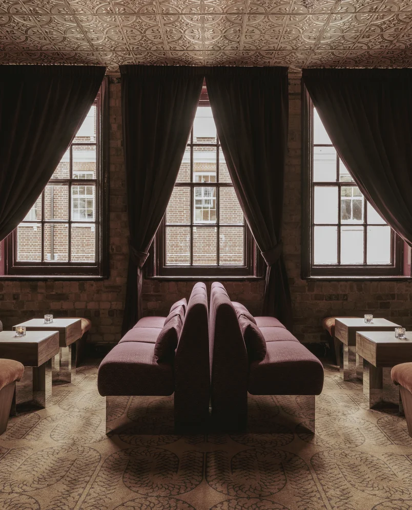 Cozy lounge with velvet banquettes and coffee tables, interior design by Experimental Group.