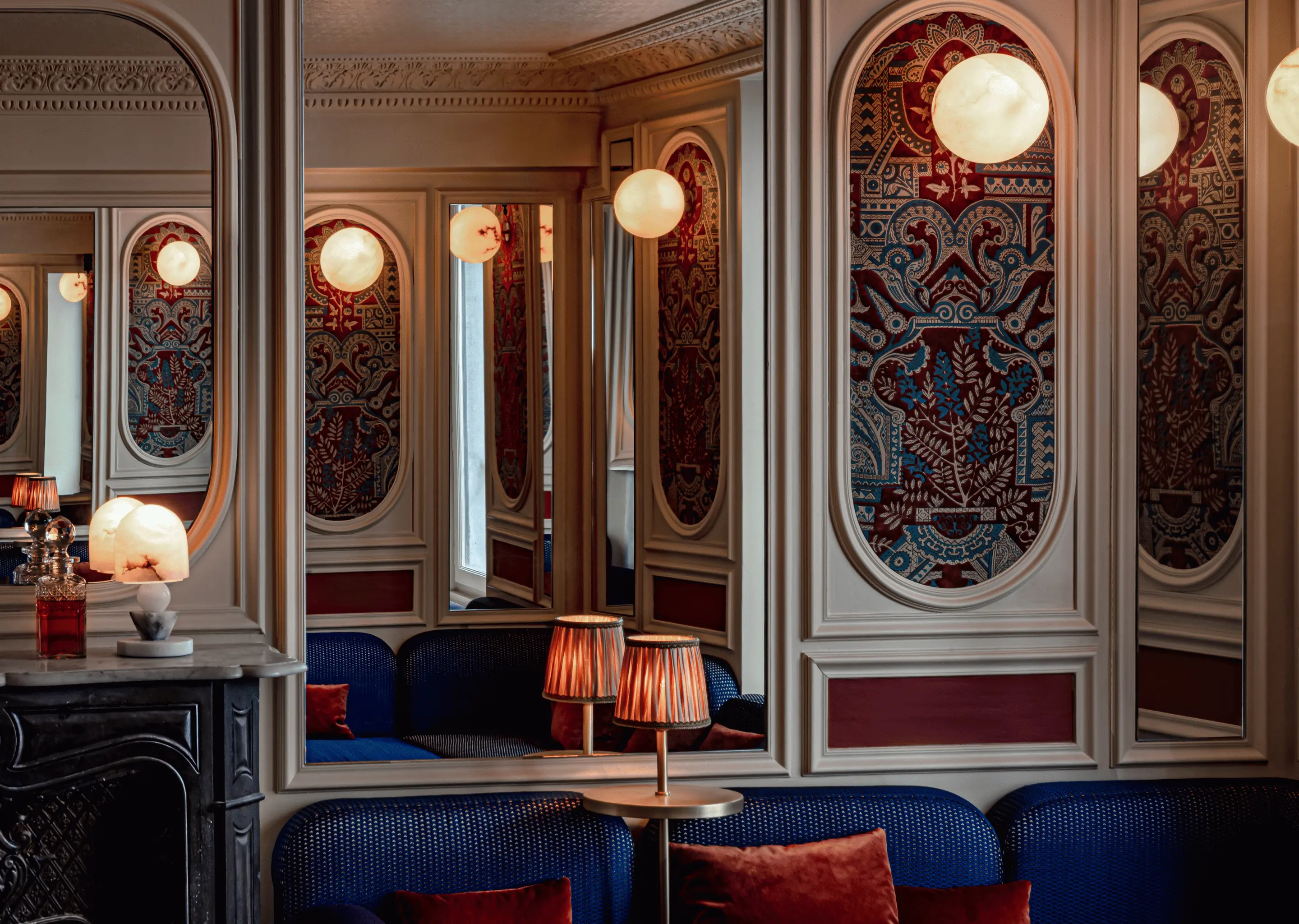 Elegant and comfortable lounge area with blue sofa, mirrors, and dimmed lighting, Experimental Group.