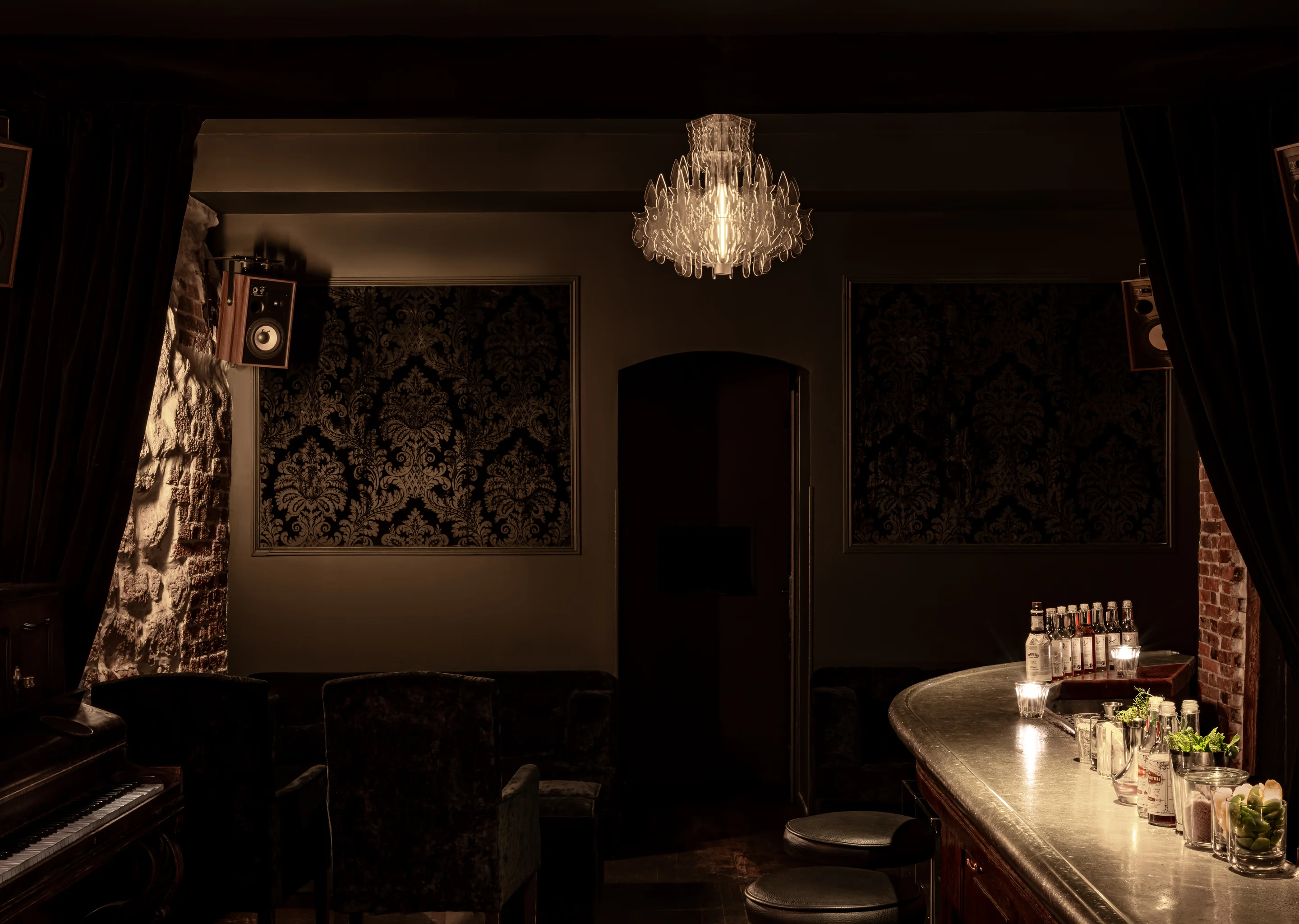 Sophisticated and intimate interior of an Experimental Group bar featuring a designer chandelier.