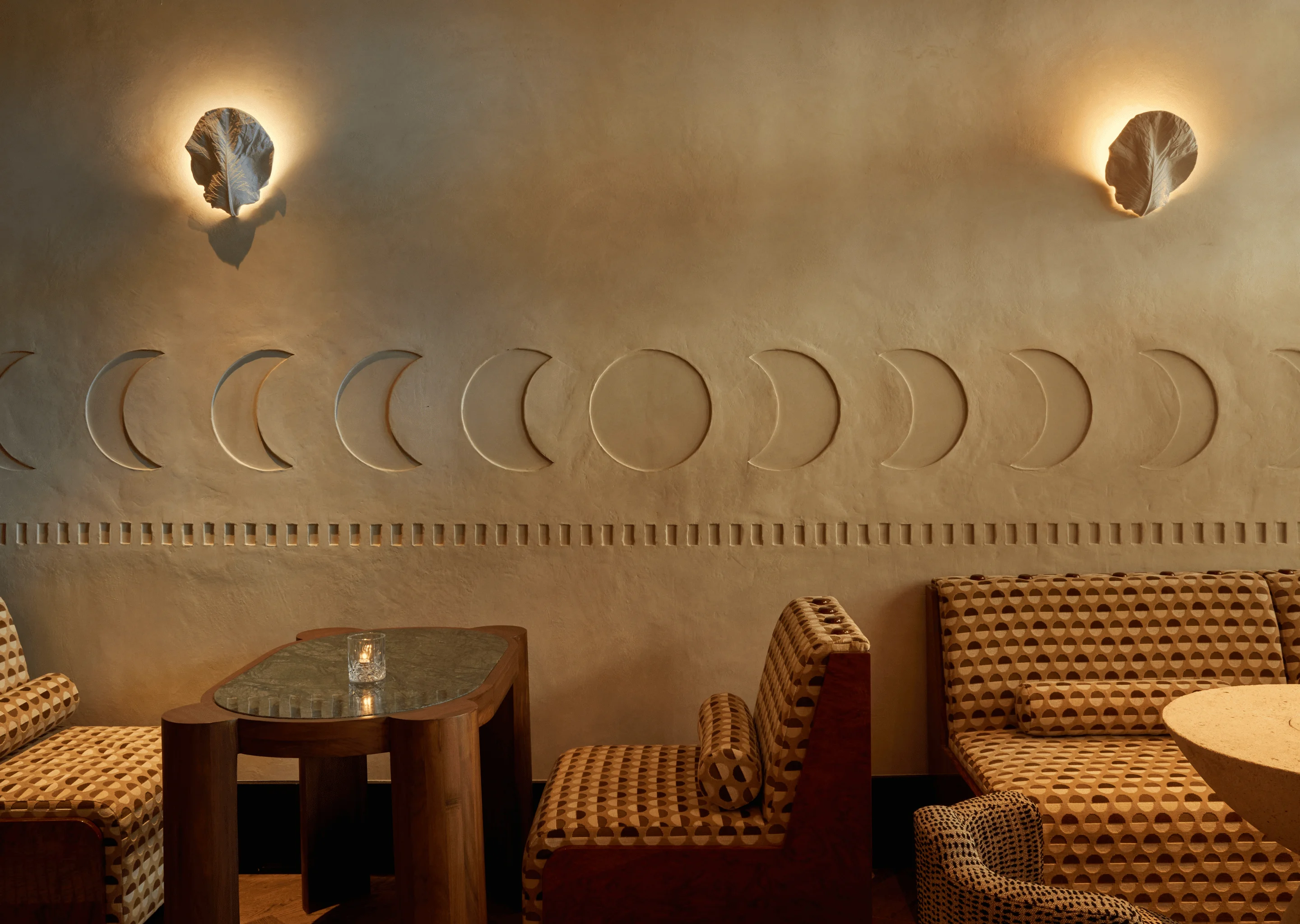 Artistic wall detail featuring moon phase carvings at La Compagnie des Vins Surnaturels, London, reflecting the bespoke design of the Experimental Group.