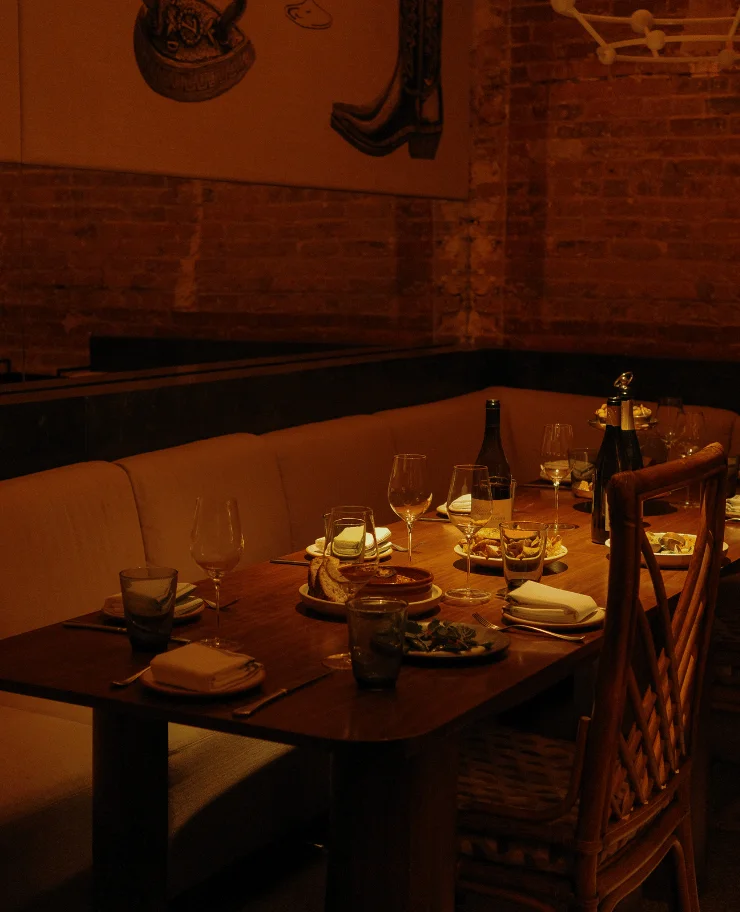 Close-up of a gourmet wine and food pairing experience on a wooden table at La Compagnie des Vins Surnaturels, London, curated by the Experimental Group.