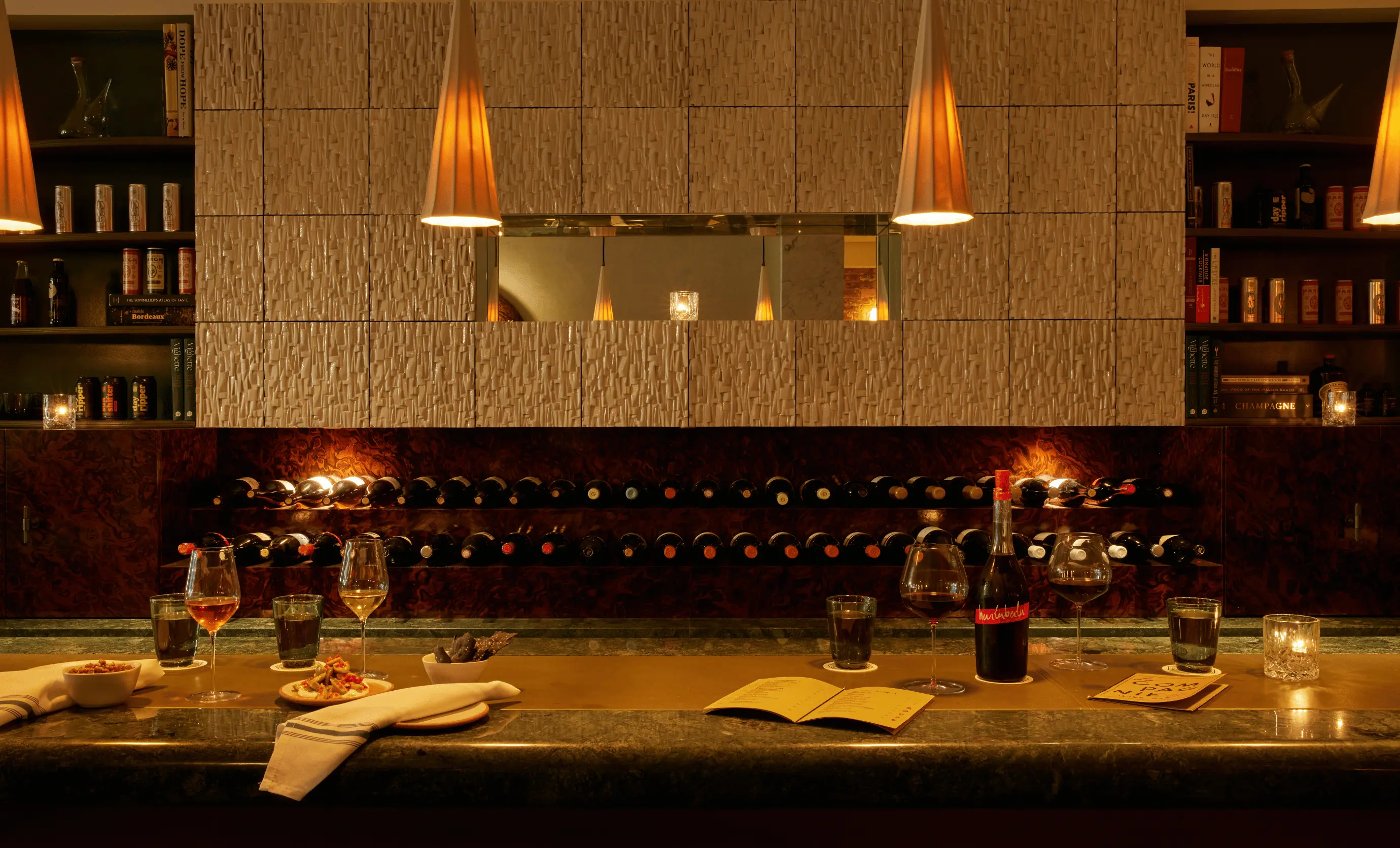 Close-up of the elegant wine bar counter at La Compagnie des Vins Surnaturels, London, featuring an extensive wine selection, curated by the Experimental Group.