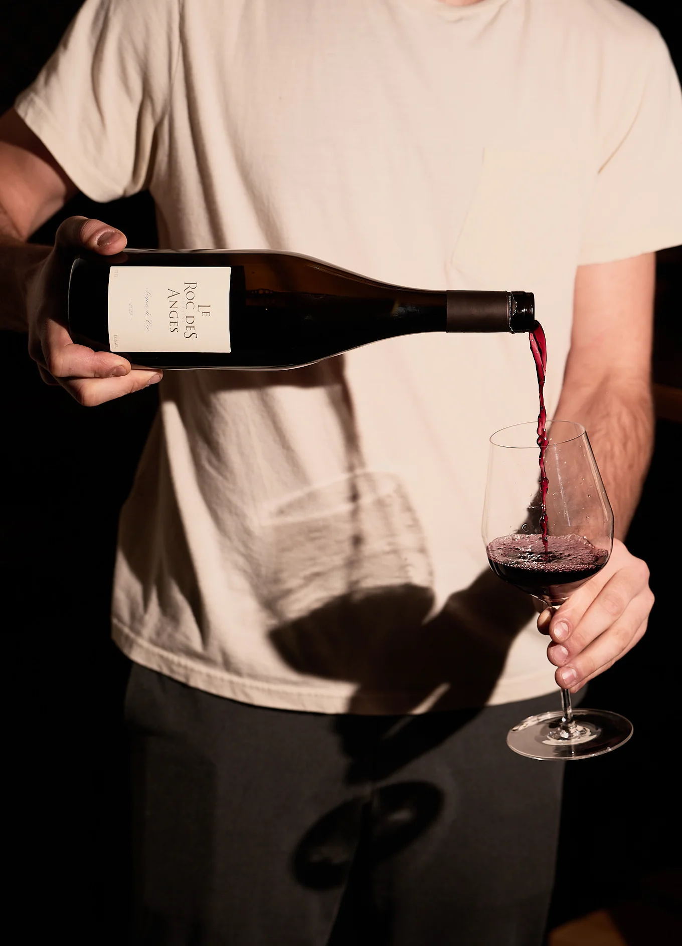 A server pouring a glass of Le Roc des Anges red wine in a sophisticated dining atmosphere, Experimental Group.