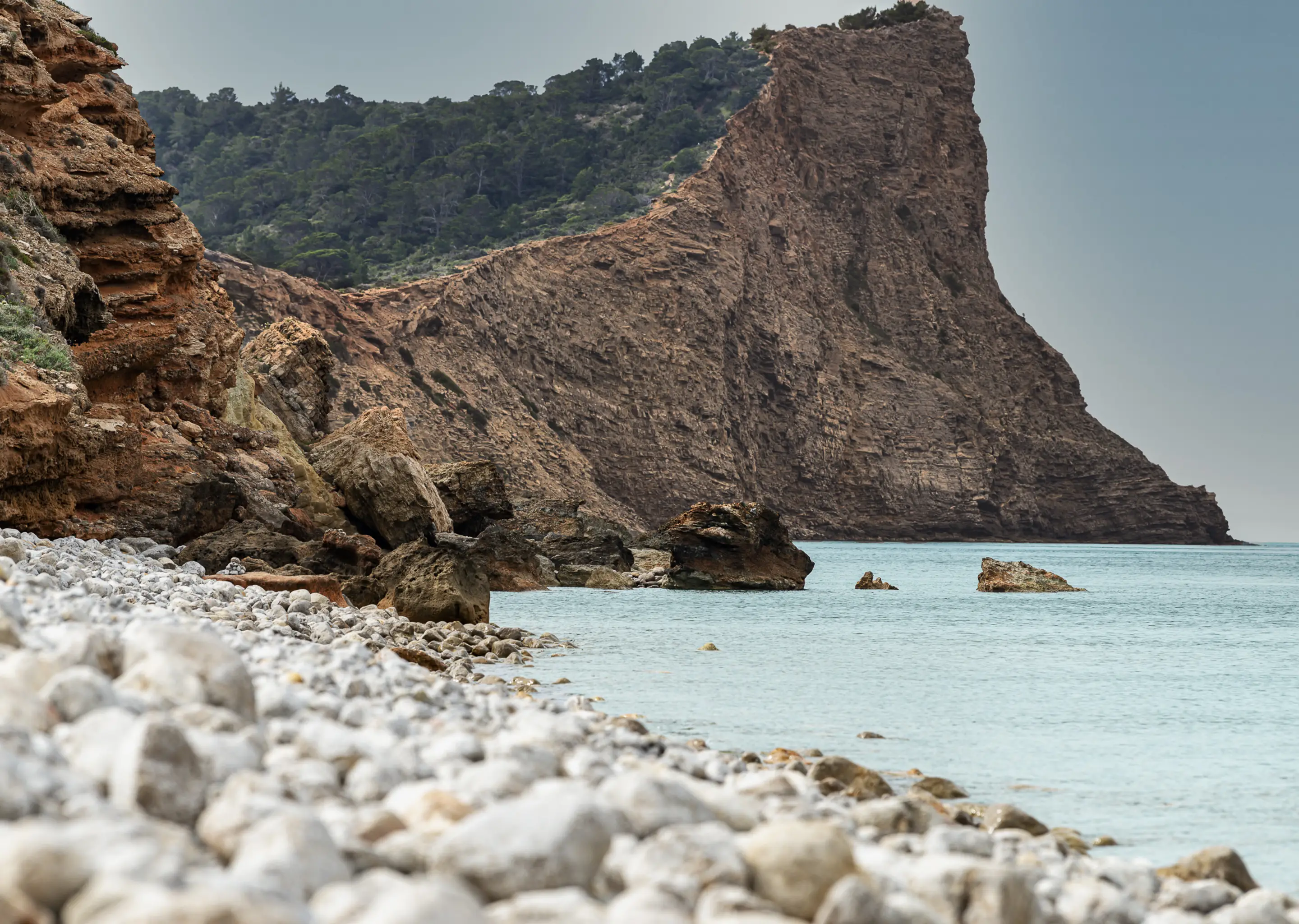 Spectacular cliffs overlooking the Mediterranean Sea on a wild beach near an Experimental Group hotel in Ibiza.