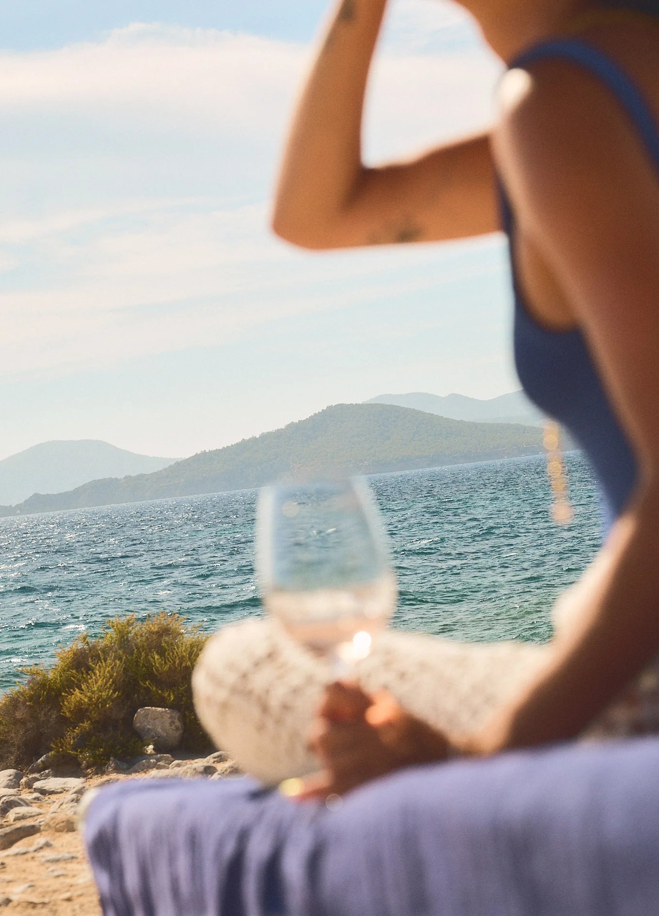 Silhouette of a person holding a glass of wine by the sea, lifestyle experience, Experimental Group, Ibiza.