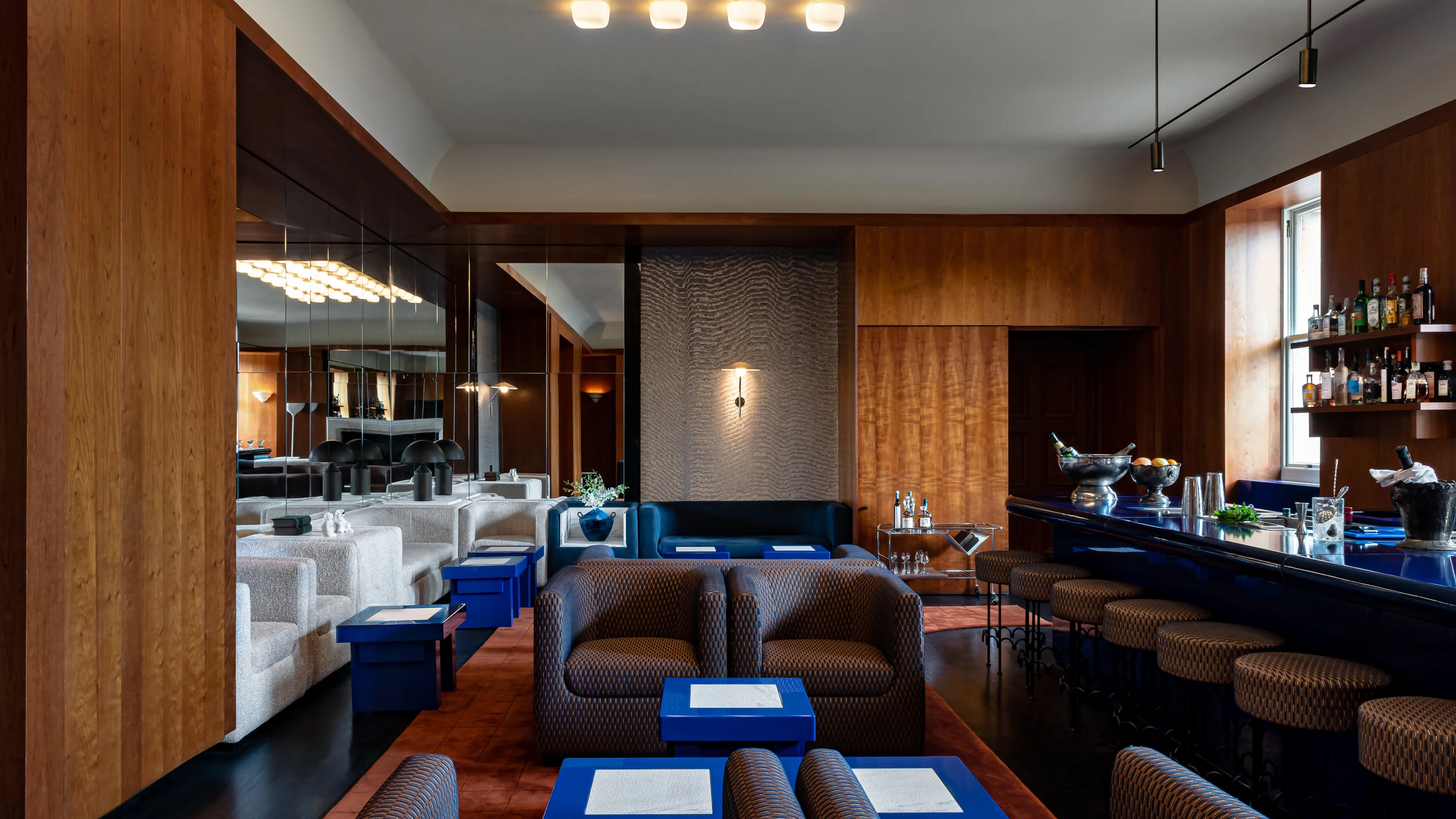Panoramic view of the elegant Experimental Group bar and lounge, featuring a blue counter and refined decor.