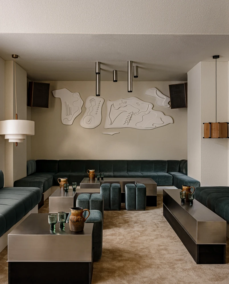 Interior design details, including abstract wall art and metal coffee tables, in the common area of the Experimental Chalet.