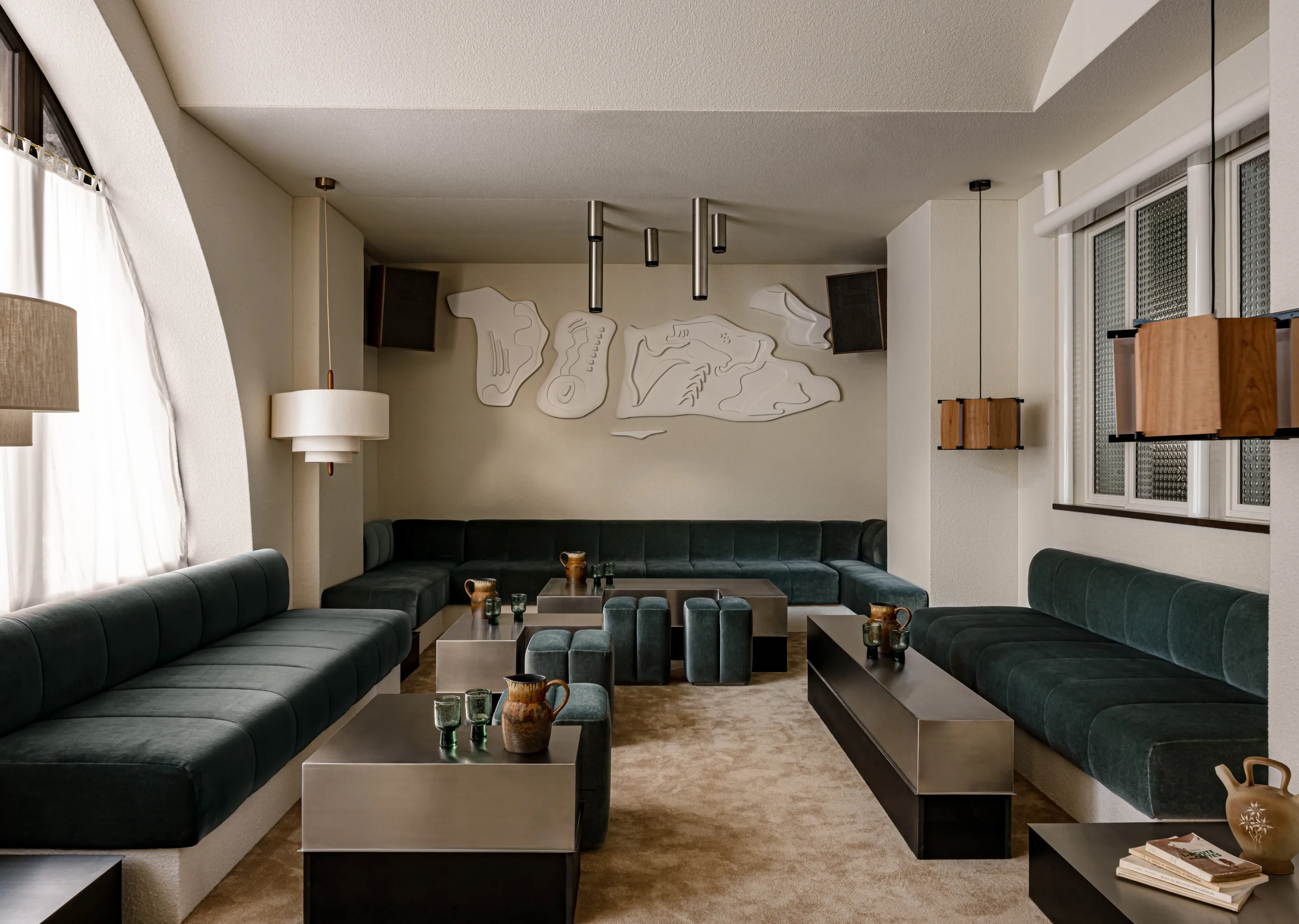 Wide shot of the sophisticated, contemporary lounge interior featuring velvet couches and art at the Experimental Chalet.