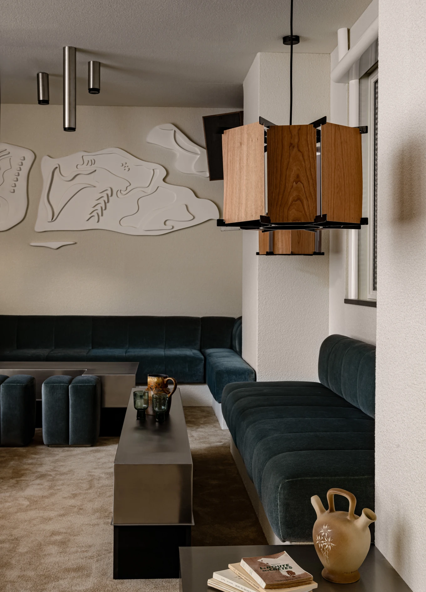 Modern, cozy lounge area with velvet seating and unique lighting at the Experimental Chalet.