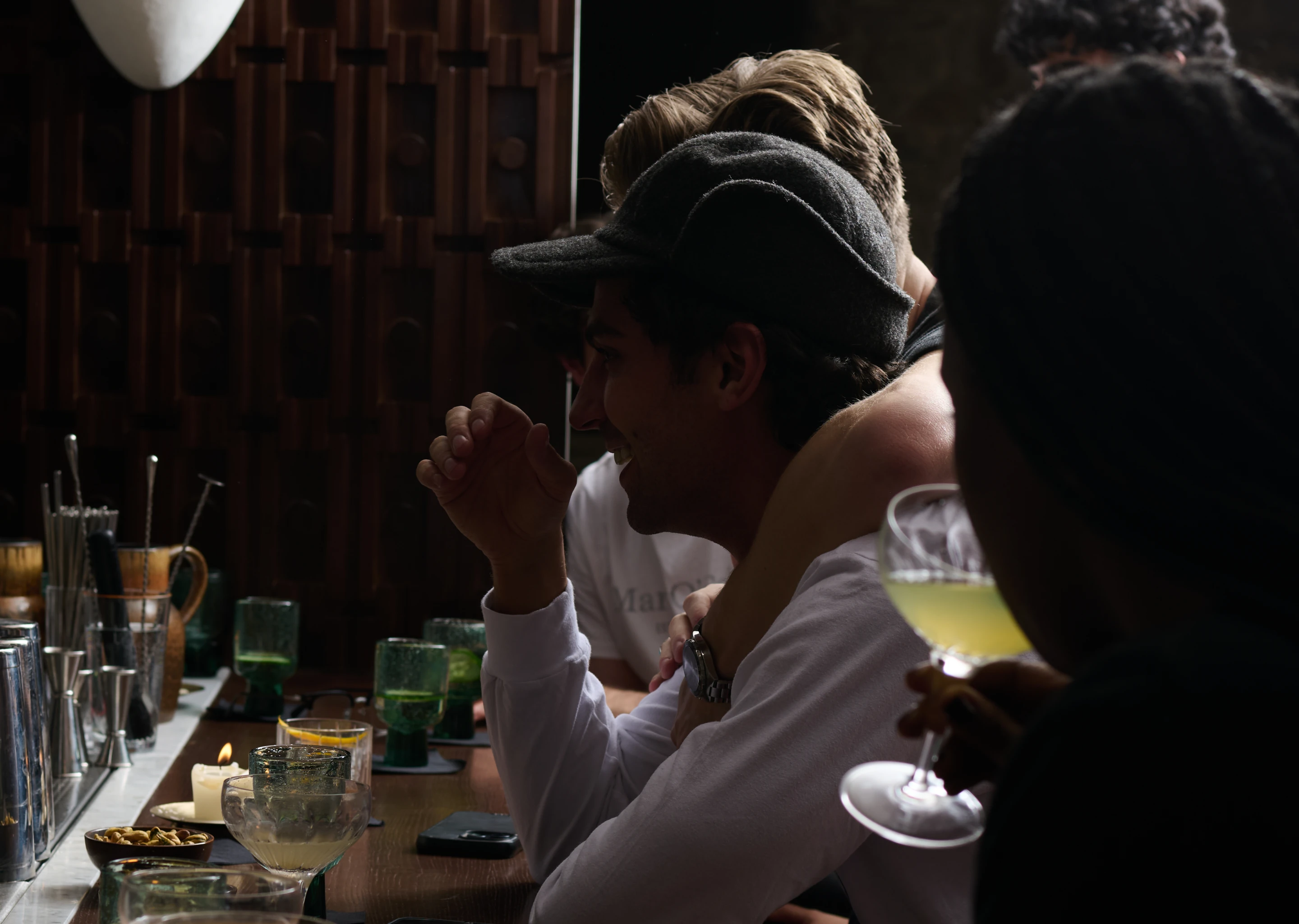 Guests socializing and enjoying cocktails at the dimly lit, stylish bar inside the Experimental Chalet.