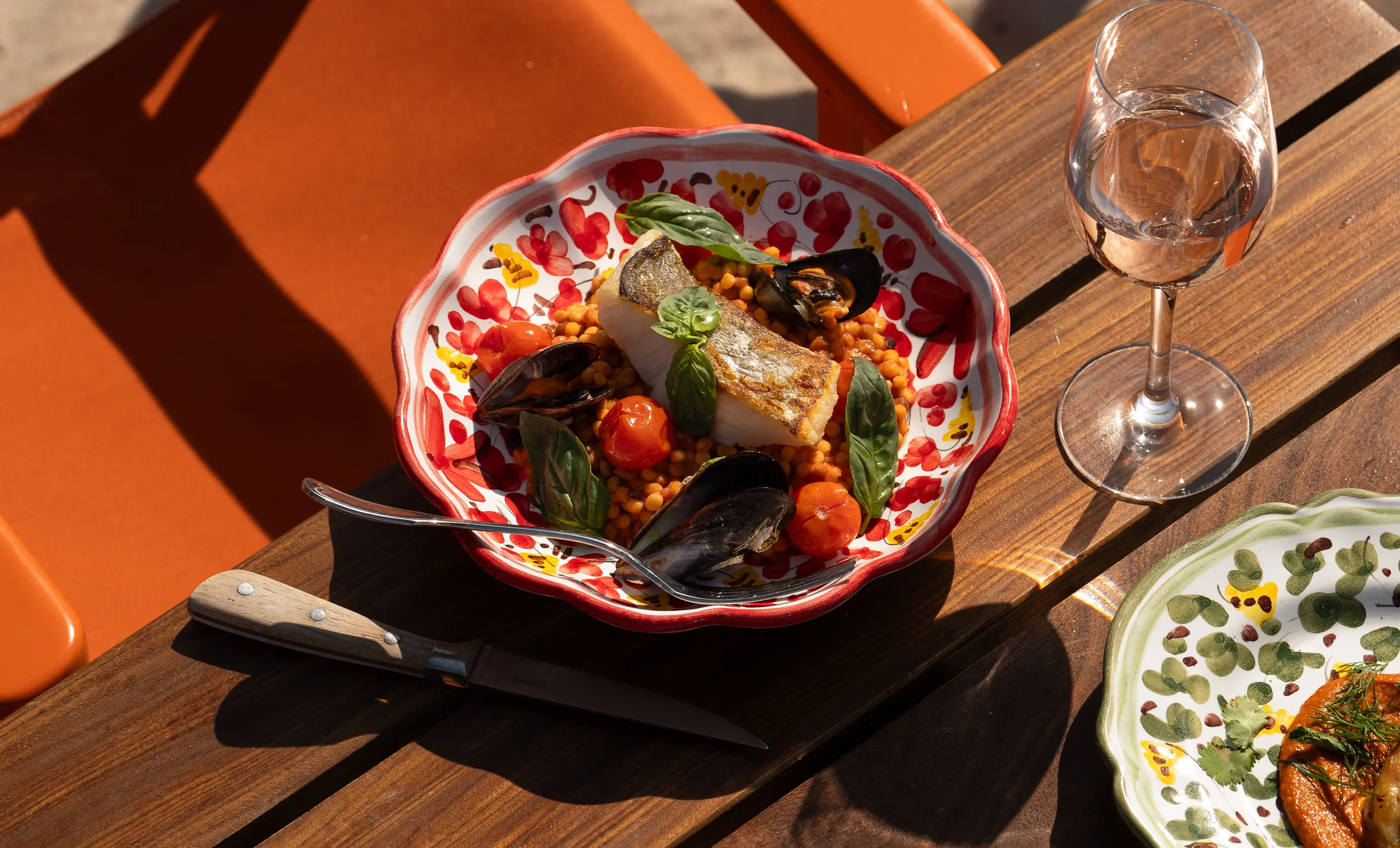 Close-up of a fresh seafood Mediterranean meal with cherry tomatoes at an Experimental Group beachfront dining venue.