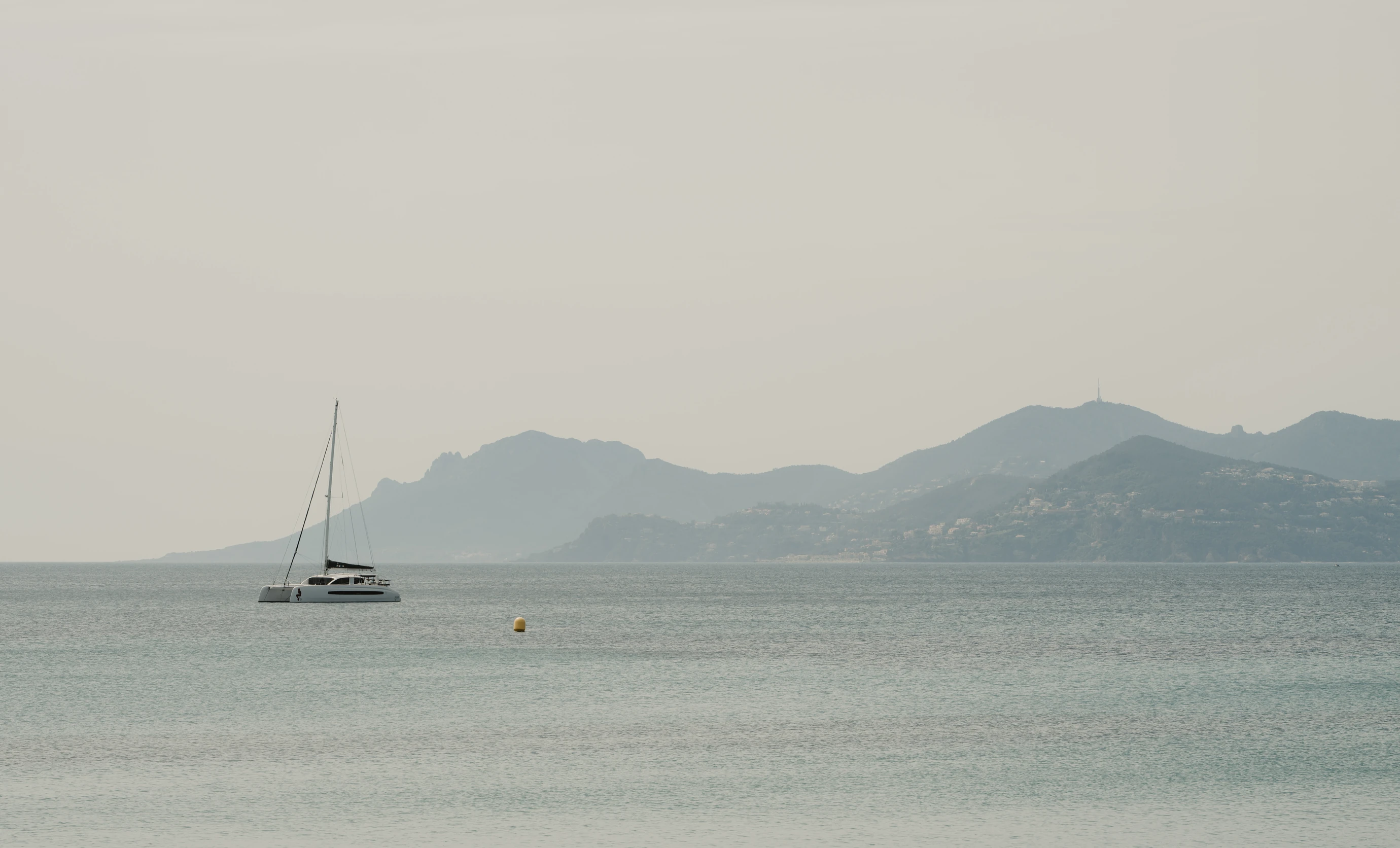 Catamaran sailing in the bay under a hazy sky, Experimental Group.