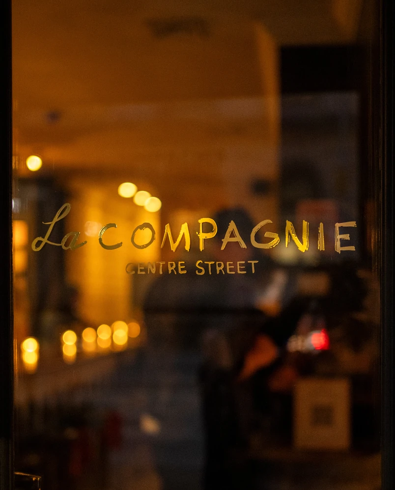 Night view of La Compagnie hotel storefront on Centre Street.