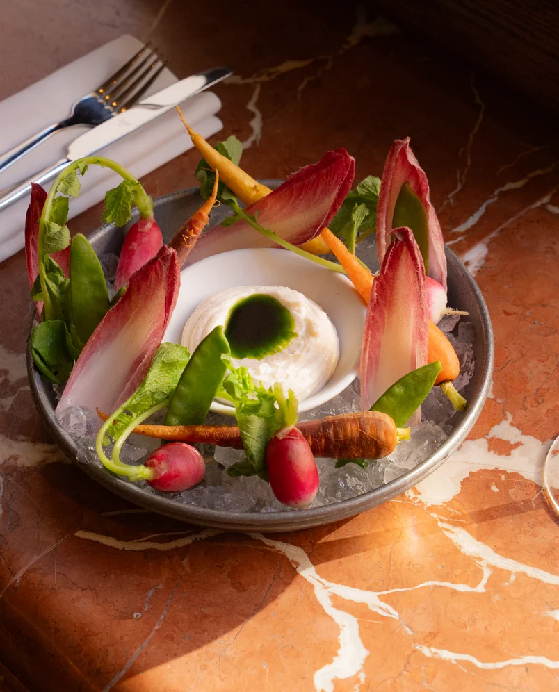 Close-up view of a crudité plate elegantly served on ice in an Experimental Group restaurant.