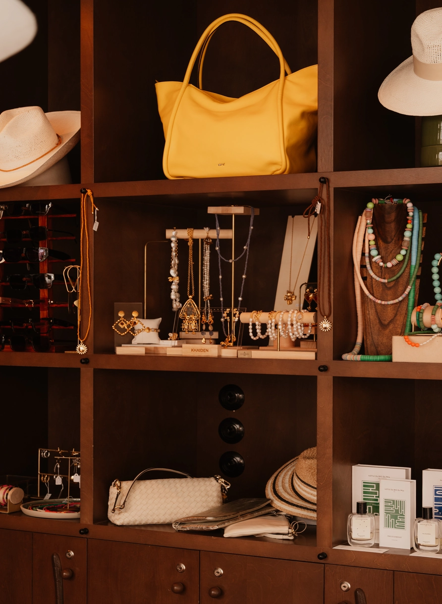 Raffinata selezione di gioielli, borse e accessori moda esposti sugli scaffali di una boutique di Experimental Group.