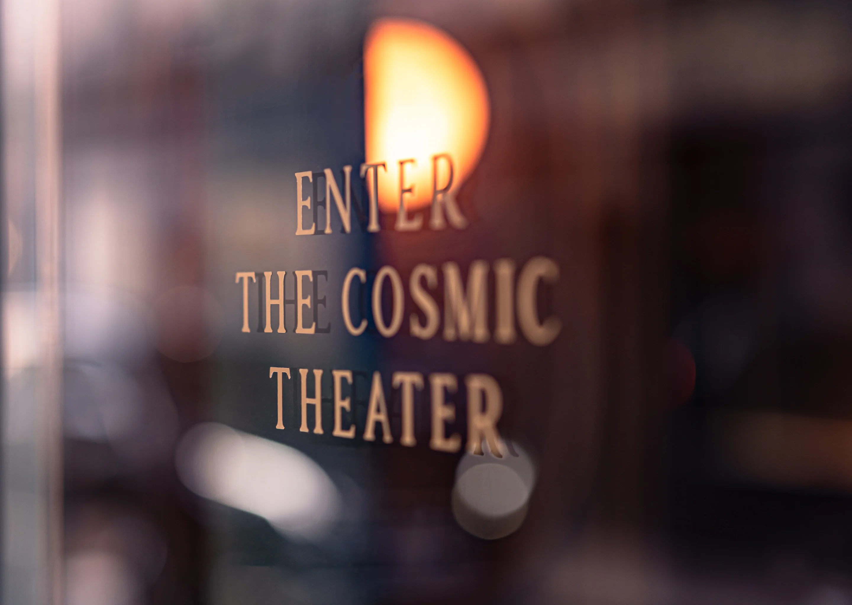 Close-up view of the "Enter the Cosmic Theater" signage at an Experimental Group venue.