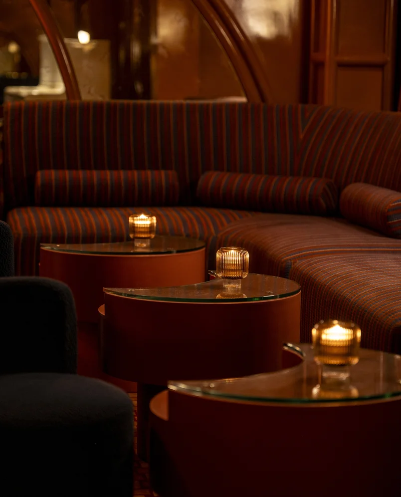 Design de interiores sofisticado com assentos confortáveis no lounge e iluminação ambiente de velas em um espaço de grupo experimental.