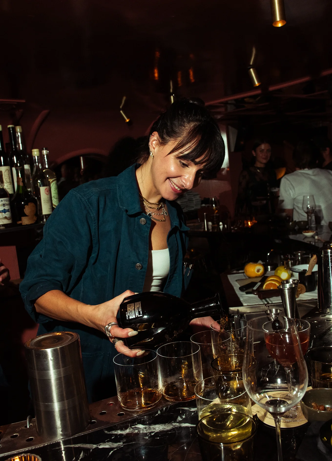 Barman preparando coquetéis exclusivos em um bar do Grupo Experimental, apresentando habilidades especializadas em mixologia.