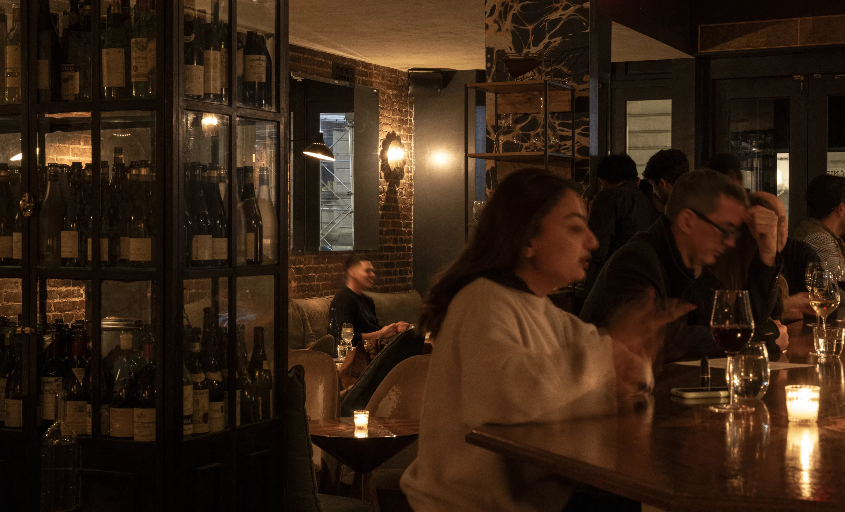 Cozy and convivial atmosphere in an Experimental Group bar with guests enjoying wine.