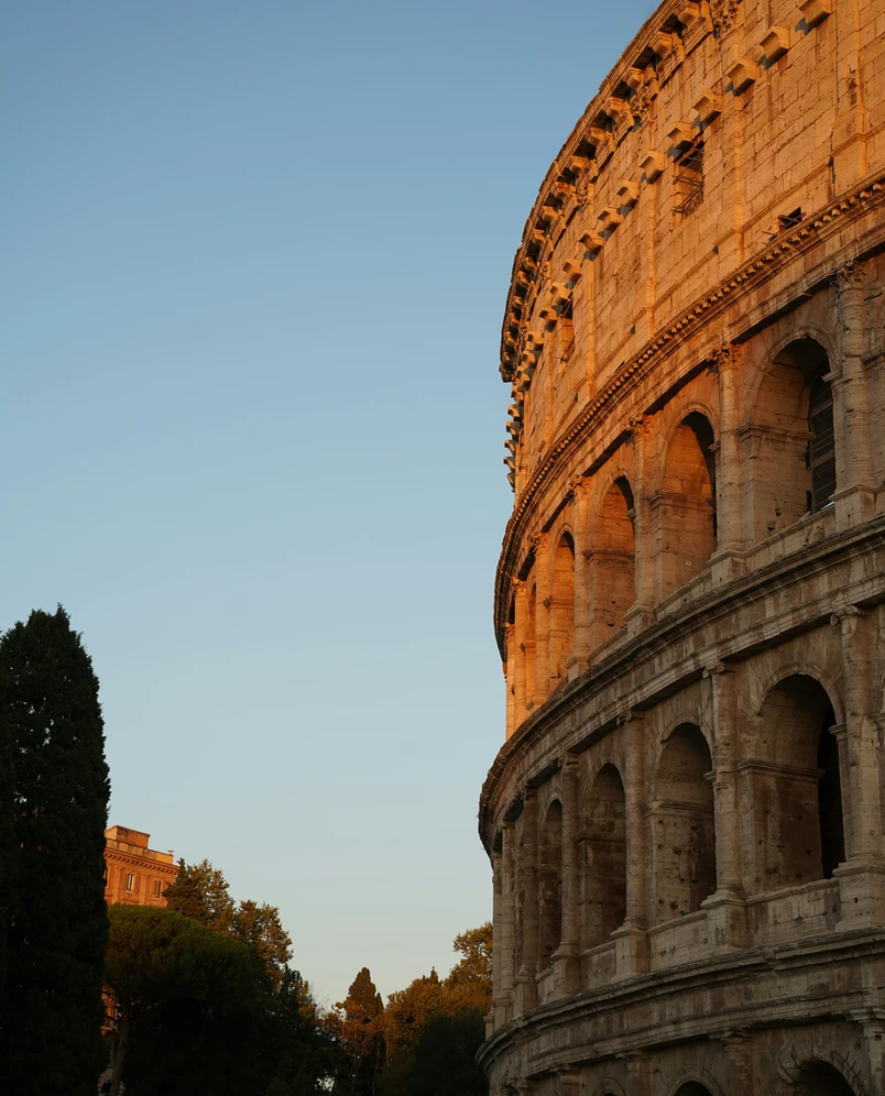 Dettaglio architettonico dello storico anfiteatro del Colosseo durante l'ora d'oro, consigliato dall'hotel Experimental Group di Roma.