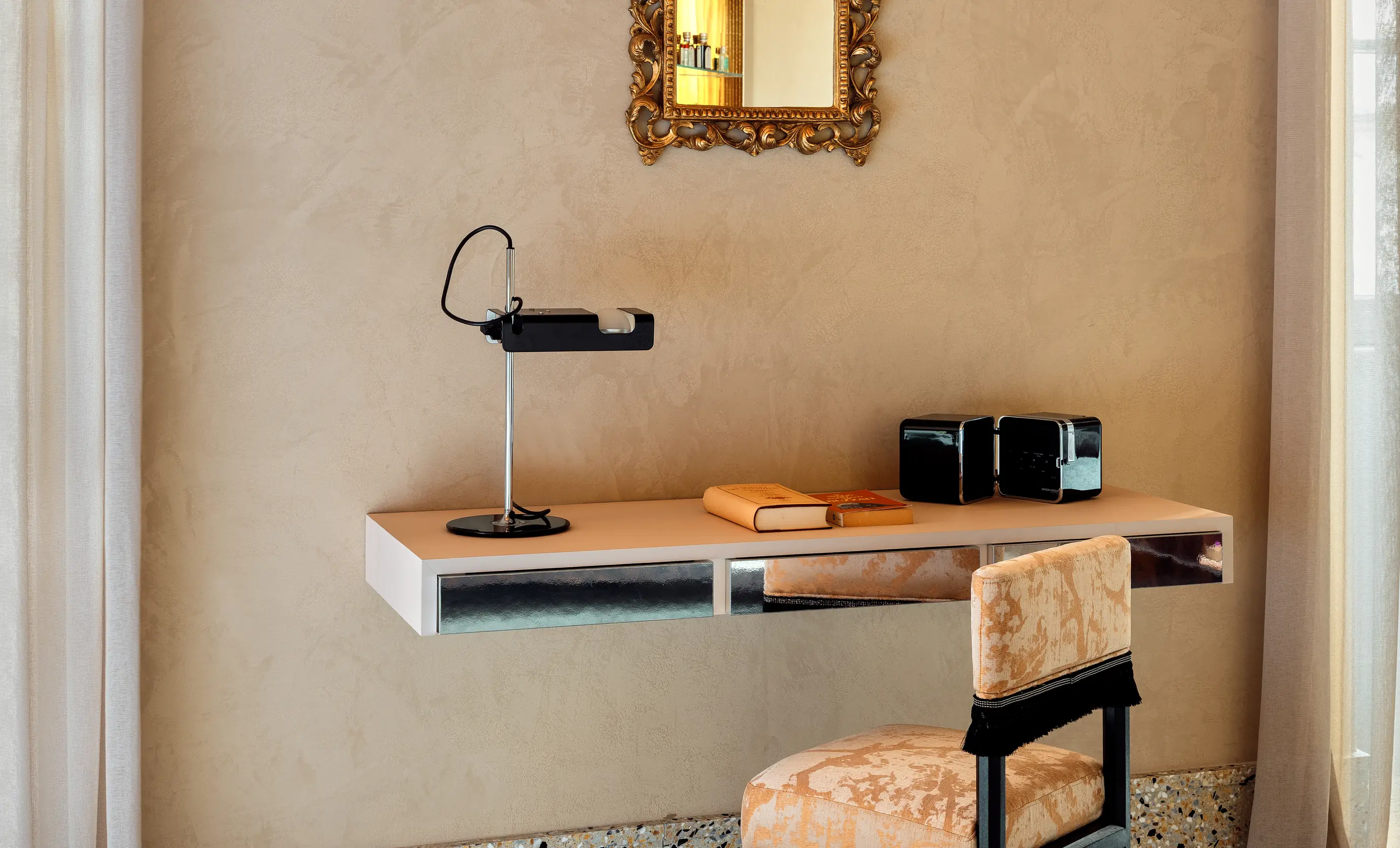 Elegant desk with a designer lamp and books in a guest room at the Regina Experimental hotel, Biarritz.
