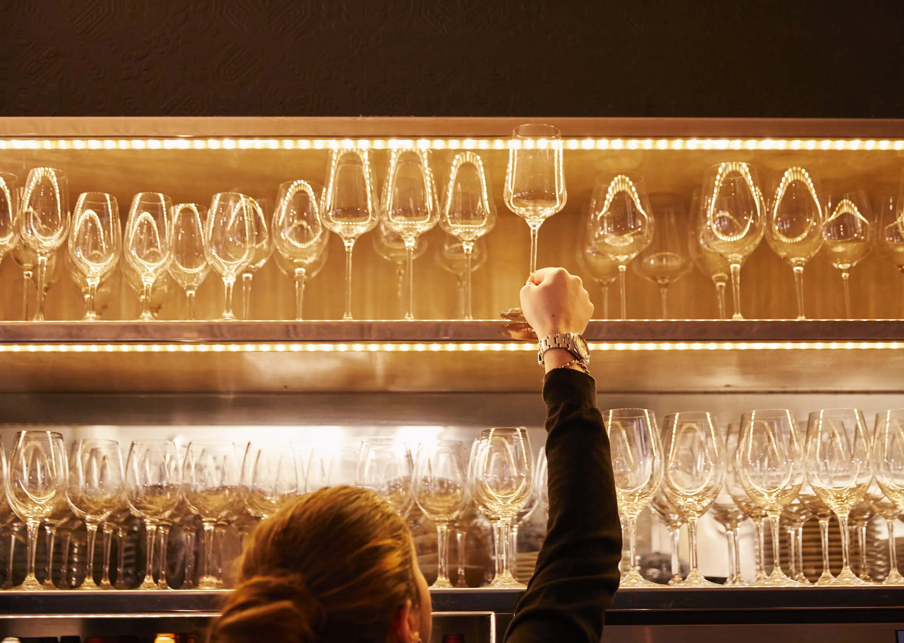 Elegant bar with rows of wine glasses, signature design by Experimental Group.