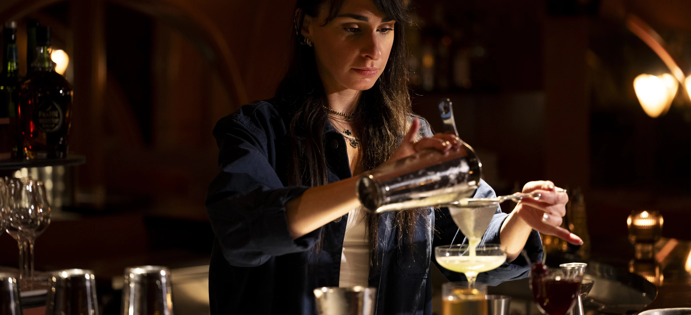 Barista professionista che prepara un cocktail con cura, immersione nel mondo di Experimental Group.