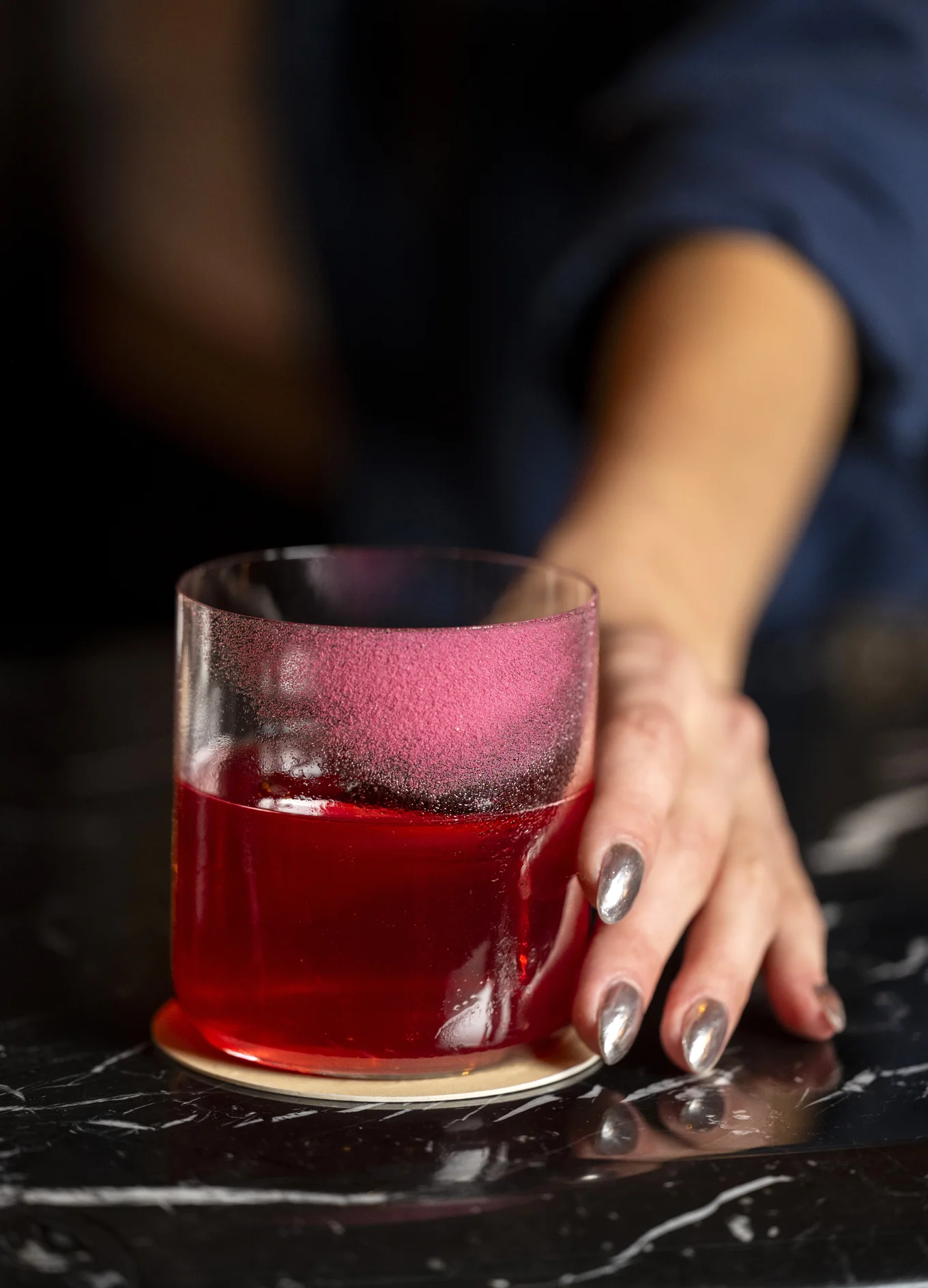 Cocktail rosso d'autore servito in un elegante bicchiere, una creazione di Experimental Group.