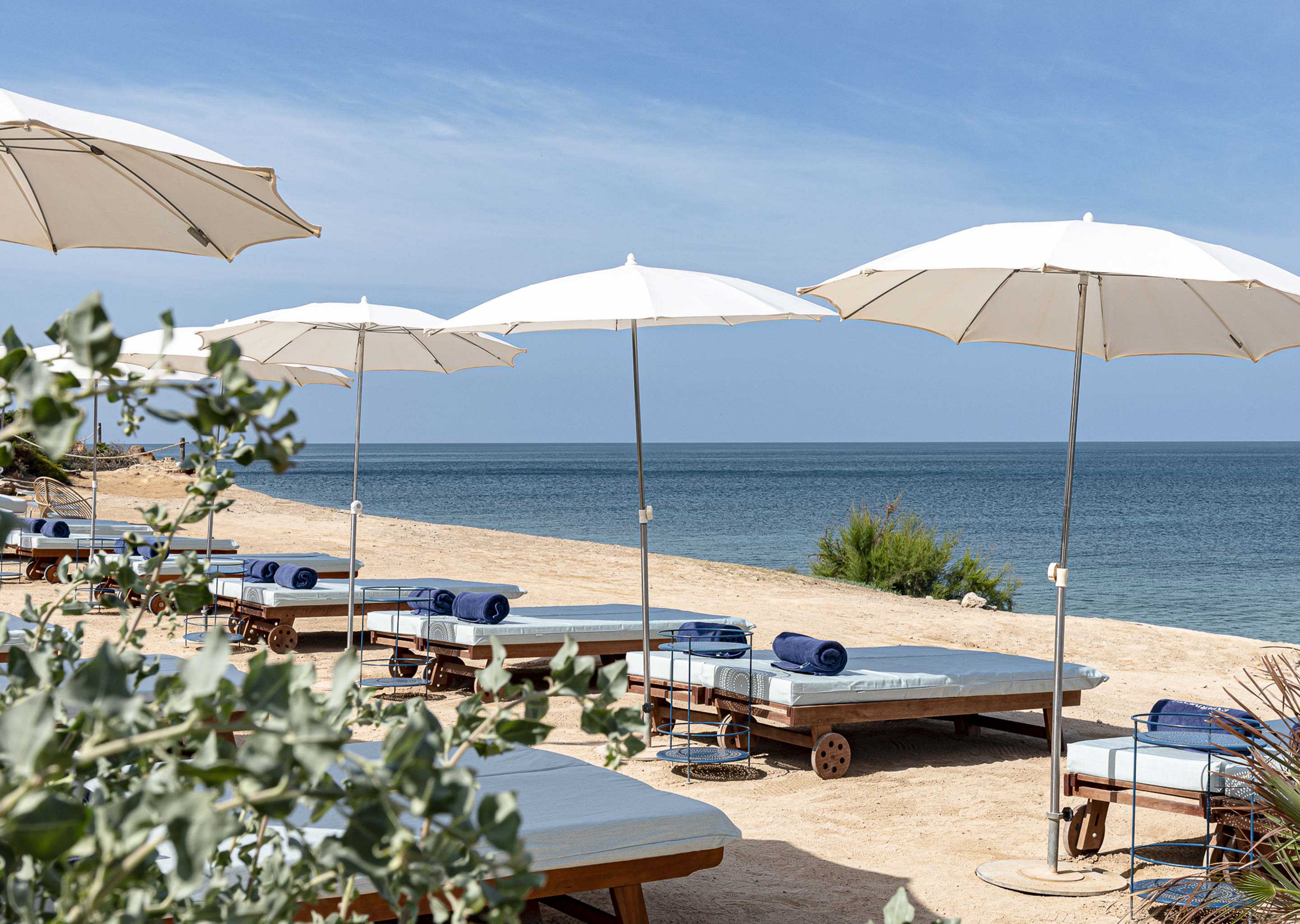 Beach setup with Experimental Group sun loungers by the sea.