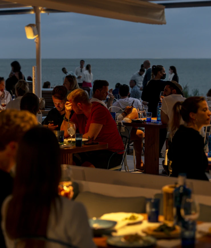 Cena serale sulla terrazza del ristorante Experimental Group con vista sull'oceano.