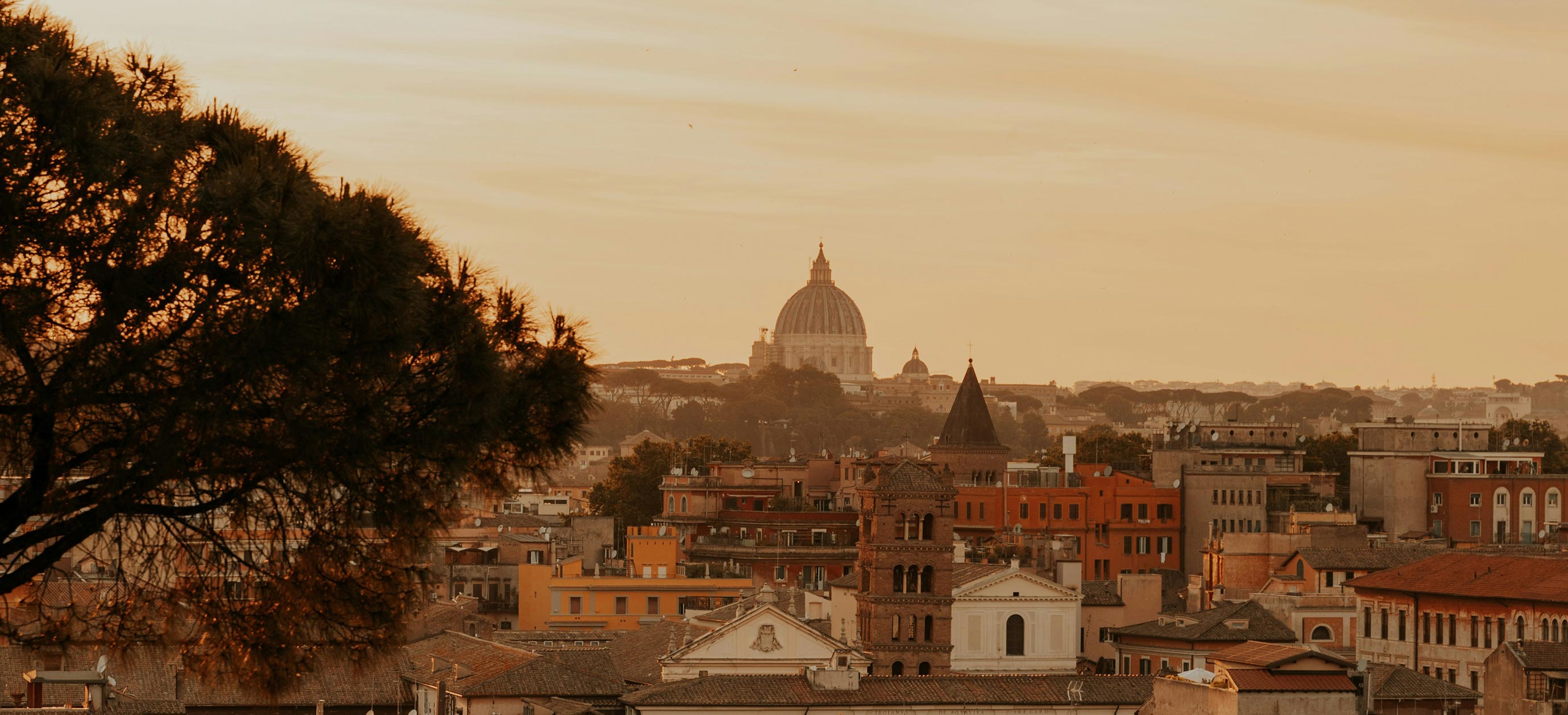 Panoramic sunset view over the rooftops of Rome, Italy.
