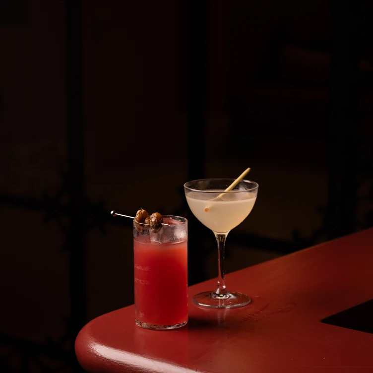 Focus on a cocktail glass placed on a white piano in an Experimental Group lounge area.