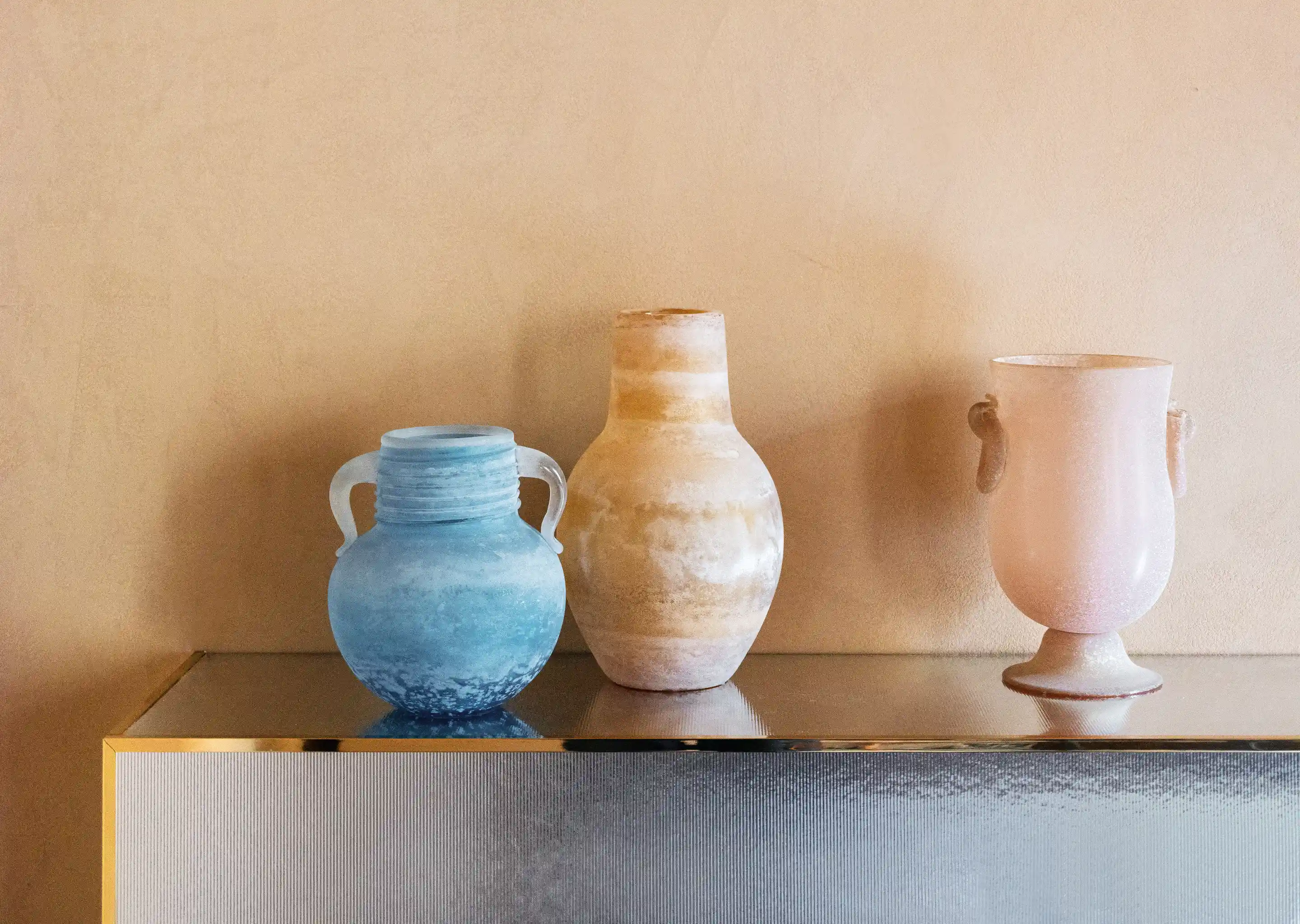 Three decorative glass vases placed on a console at Palazzo Experimental, Venice.