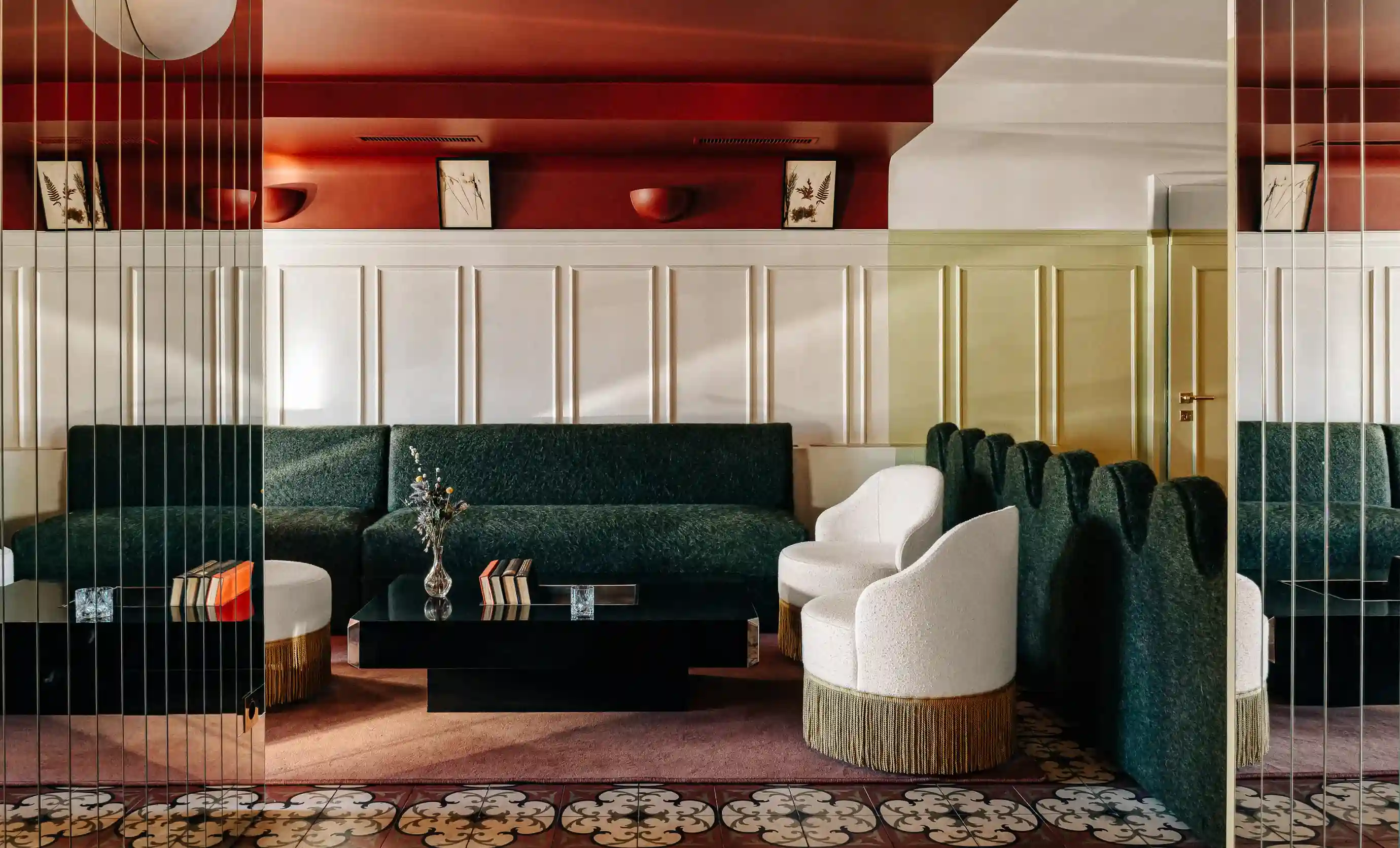 Sala de estar moderna com sofá verde, duas cadeiras brancas, mesa de café preta e painéis decorativos de parede.