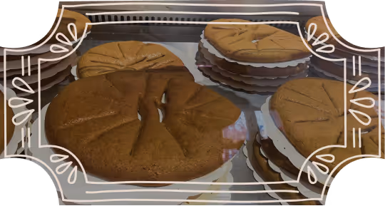 Biscuits ronds dorés fourrés de crème blanche présentés en piles sur un plateau.