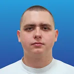 Portrait of a young man with short hair wearing a white shirt against a blue gradient background.