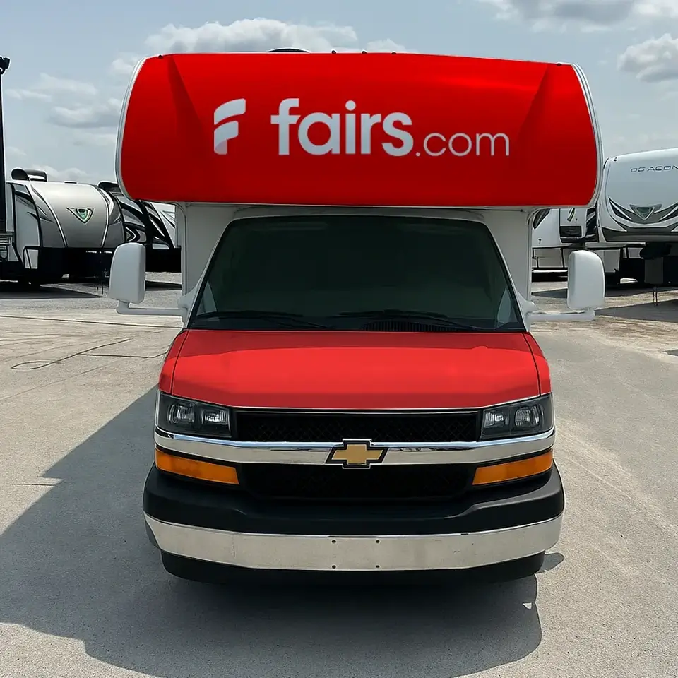 Front view of a red and white Chevrolet RV with fairs.com logo on the upper front.