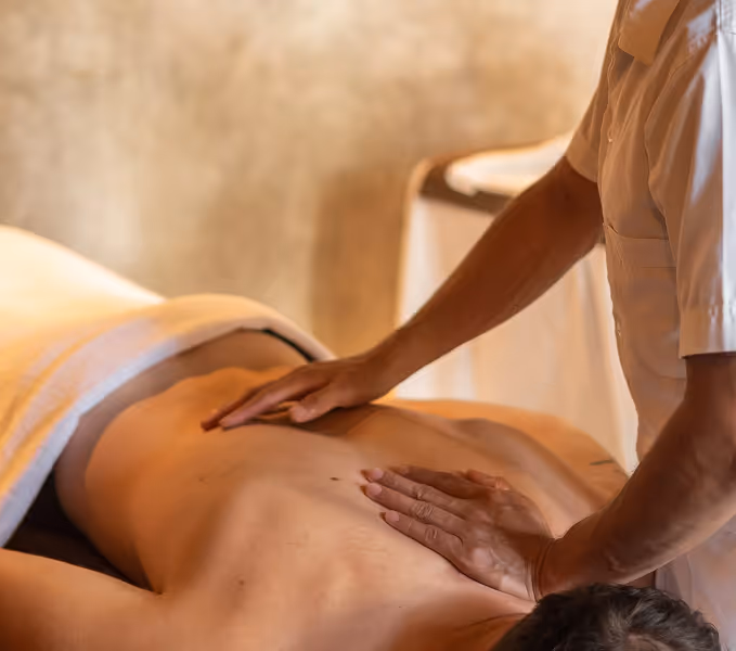 Un hombre recibe un masaje profesional de espalda en el sereno spa del hotel La Valise Tulum.