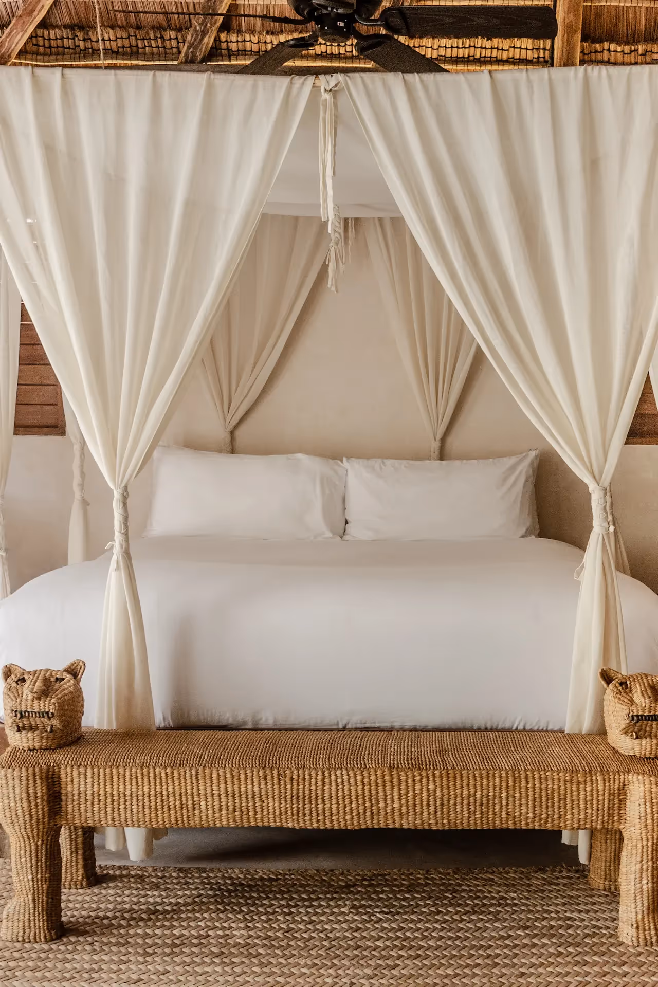 Luxurious bedroom at La Valise Tulum hotel featuring a white canopy bed, elegant curtains, and artisanal decor in Mexico.